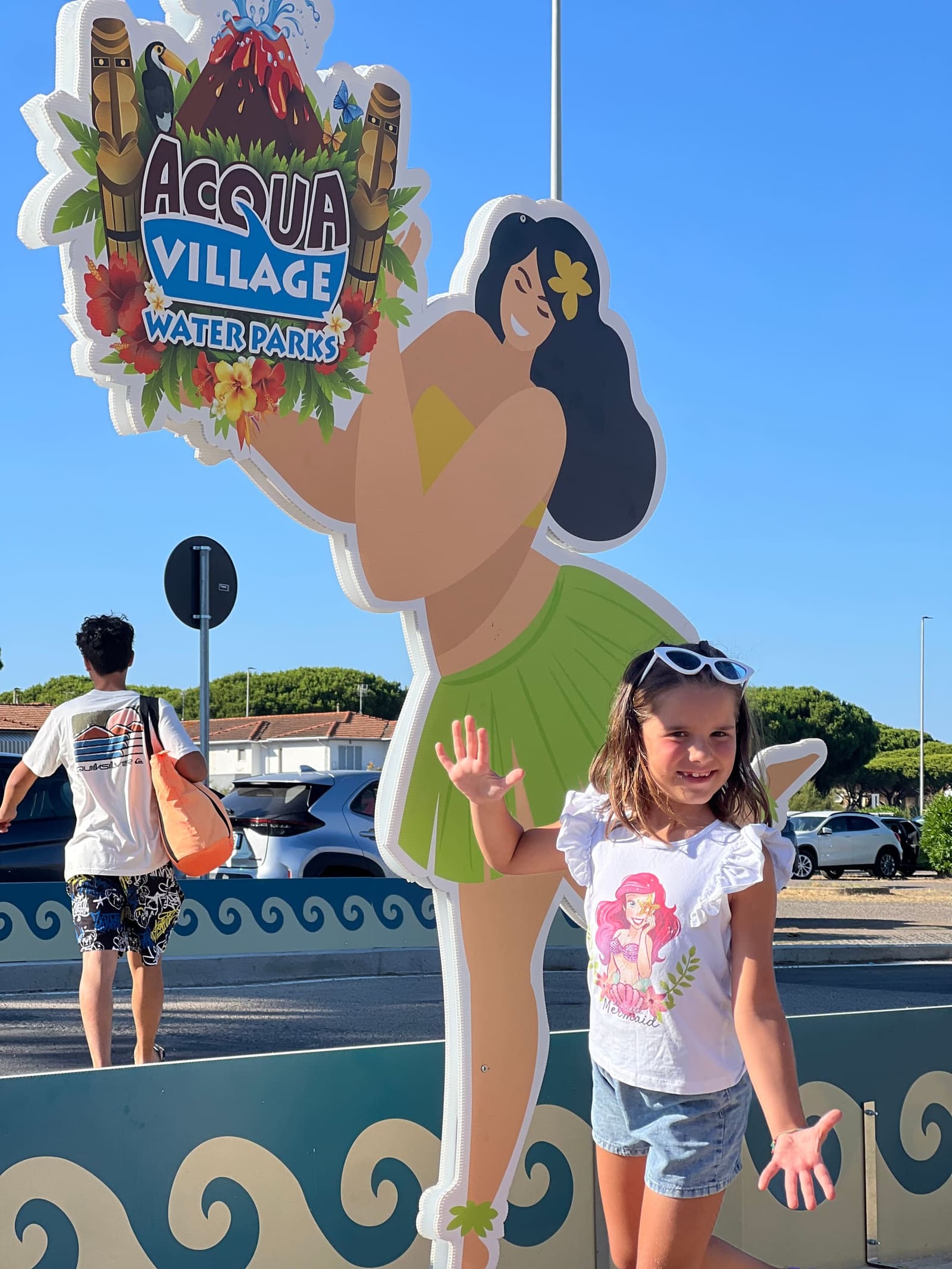 nostra figlia saluta la hula girl dell'insegna, uscendo alla chiusura