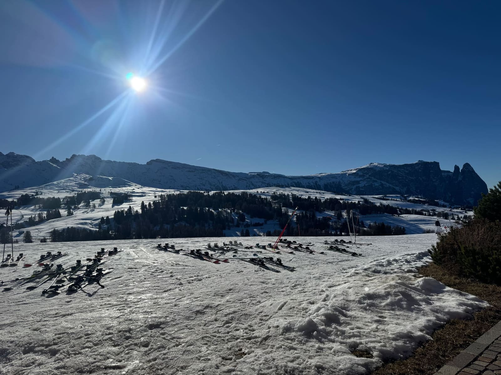 gli sci piantati nella neve davanti all'albergo, e in fondo lo Sciliar con le sue due torri