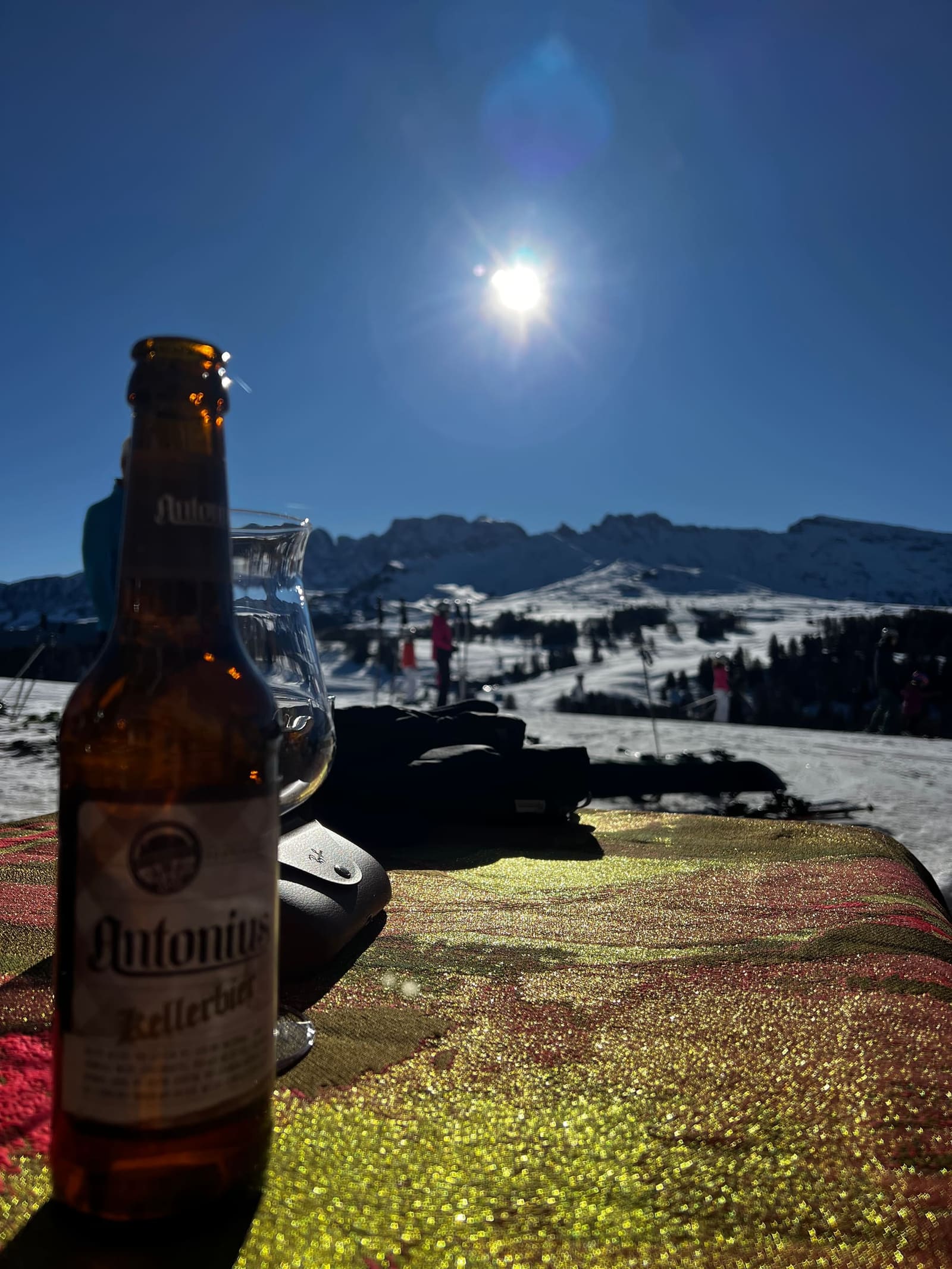 una Kellerbier Antonius sul tavolo al sole, e gli sci piantati nella neve dietro