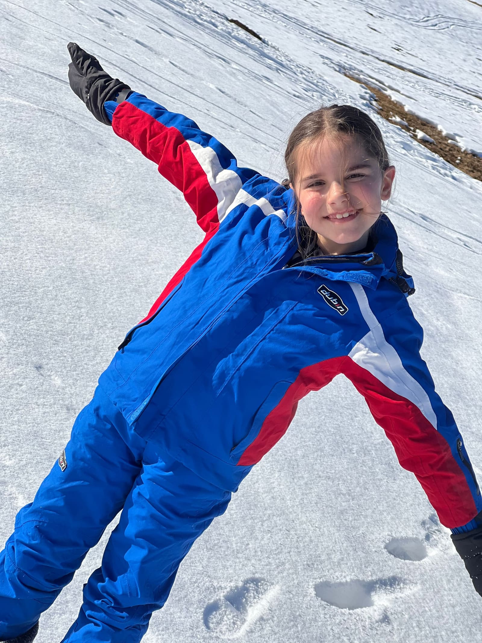 Letizia a braccia aperte sulla neve, nella tuta blu
