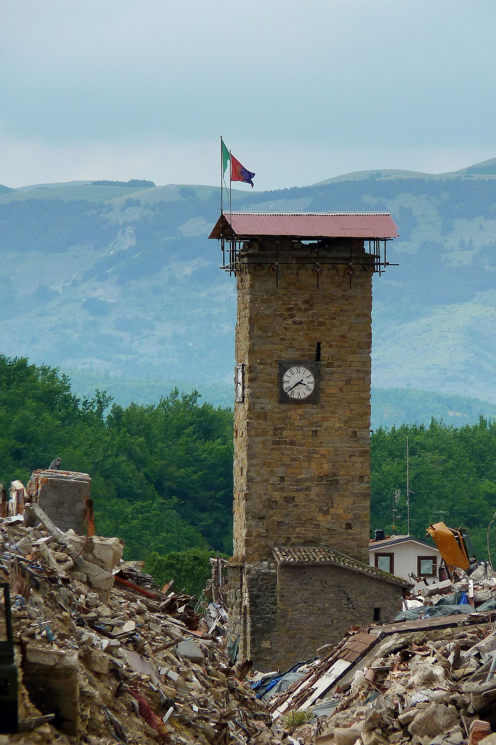 la torre civica nel giugno 2017, rimasta in piedi fra le macerie, con l'orologio fermo all'ora della scossa