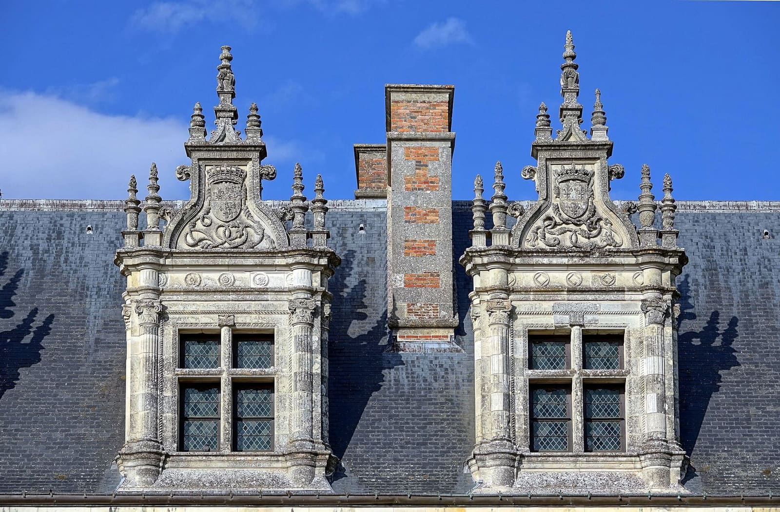 deux lucarnes sculptées sur le toit d'ardoise du château