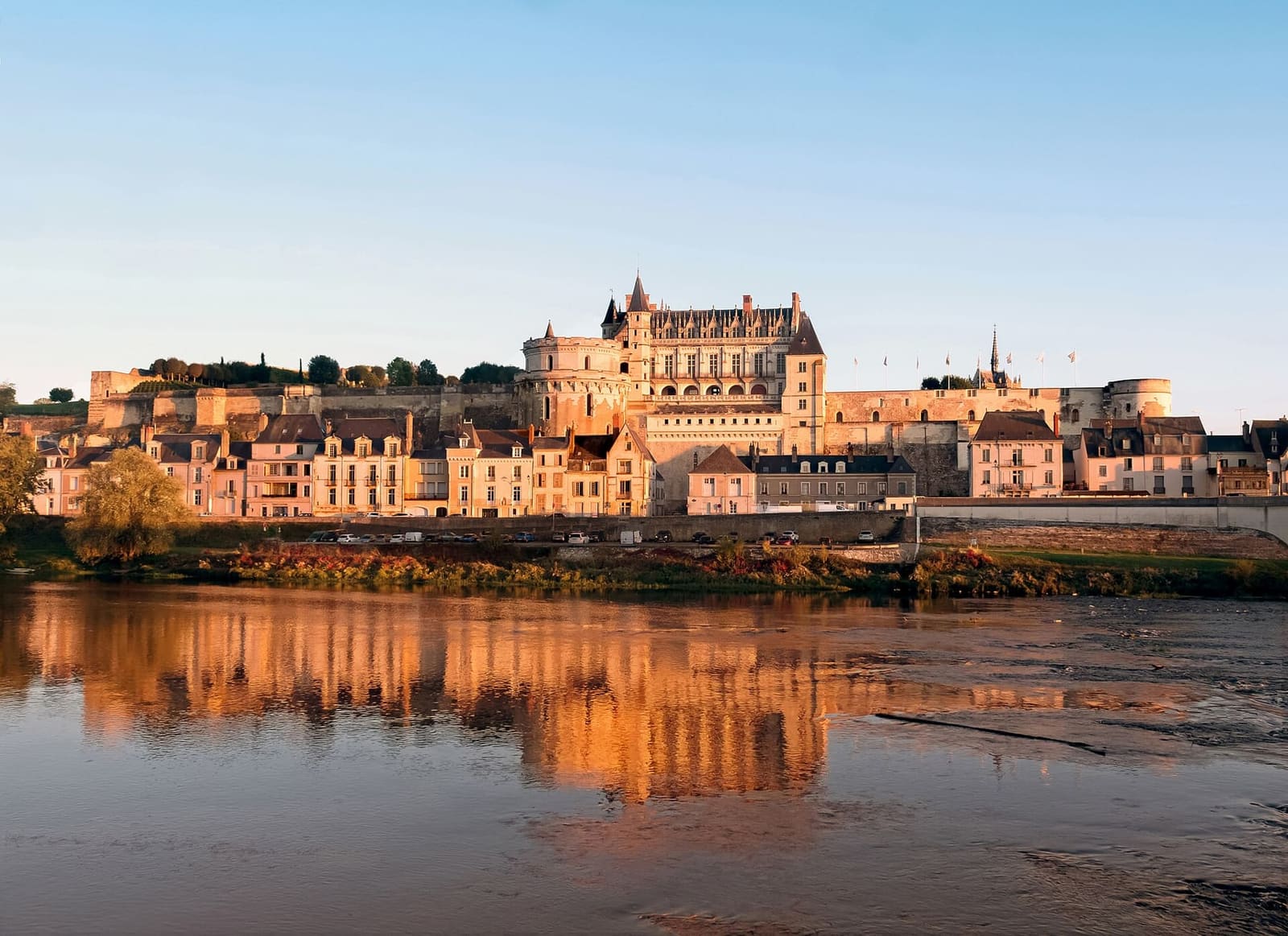 le Château royal d'Amboise éclairé par le dernier soleil et reflété dans la Loire
