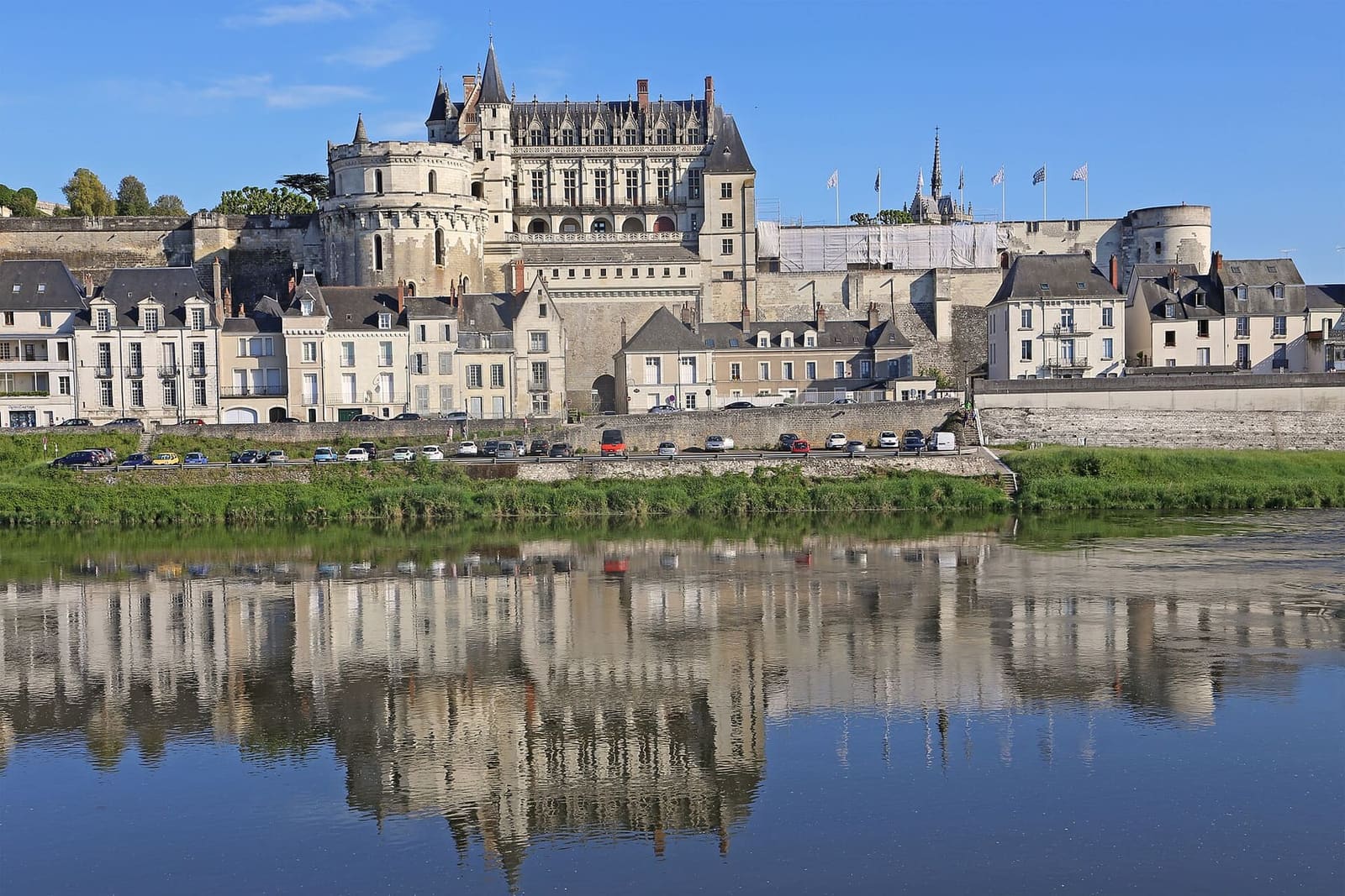 le château au-dessus des maisons des quais, reflété dans la Loire sous le ciel bleu
