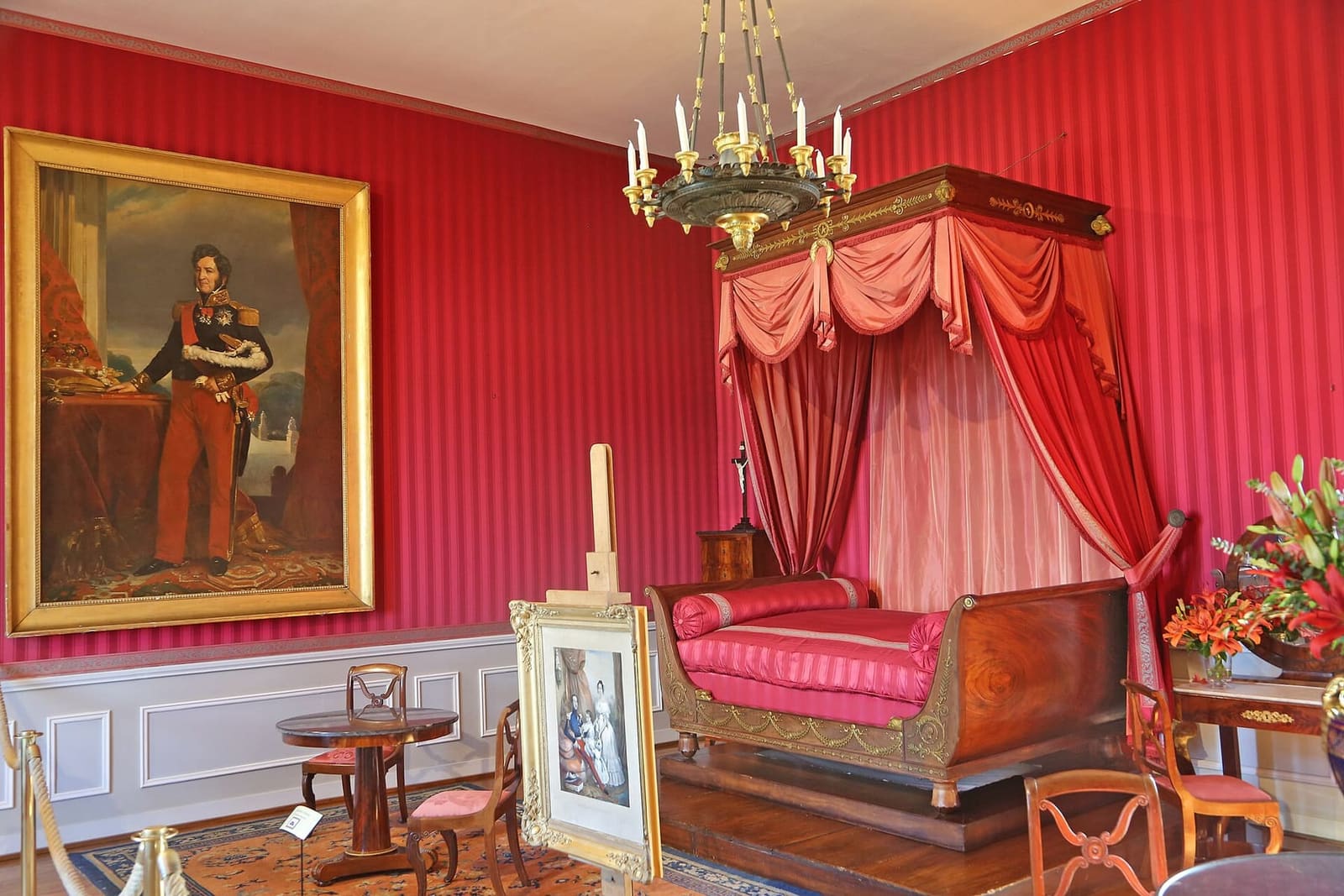 une chambre du XIXe siècle dans le château, aux murs rouges, avec un lit à baldaquin