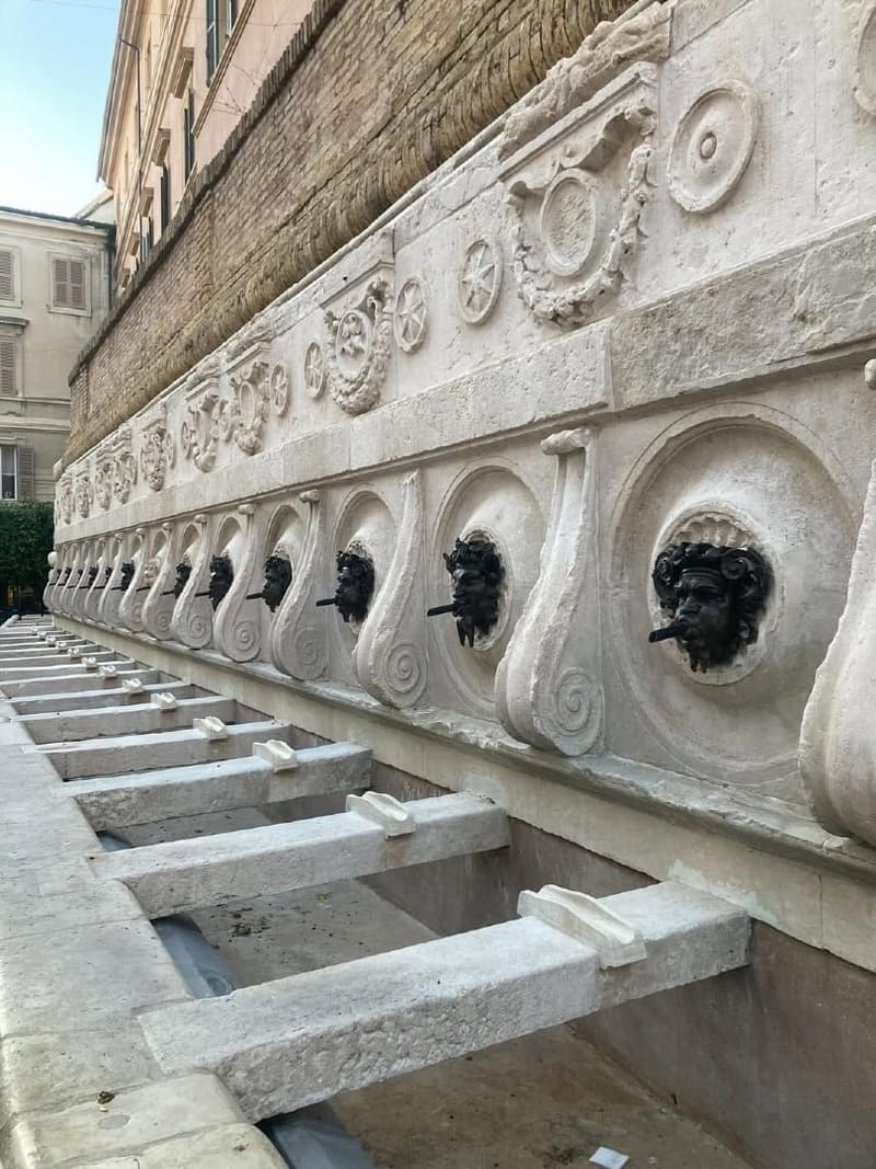 i mascheroni di bronzo e le vasche di pietra della Fontana del Calamo