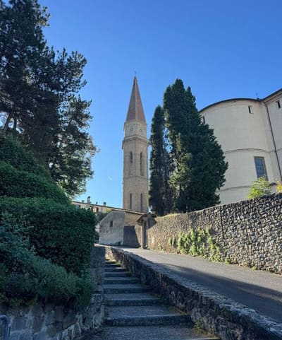 la salita a gradini verso il campanile con l'orologio, fra siepi e muri di pietra