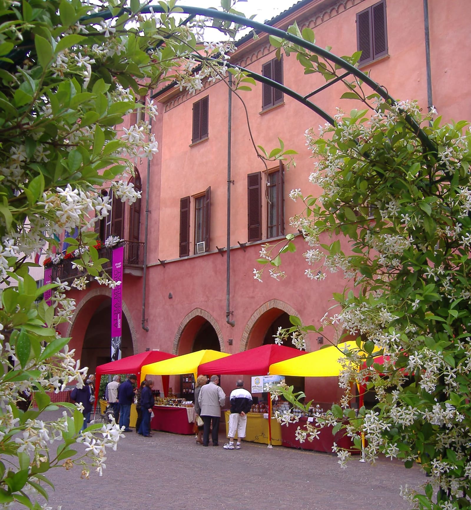 i banchi sotto i portici del municipio, in Piazza Risorgimento, durante una festa di primavera