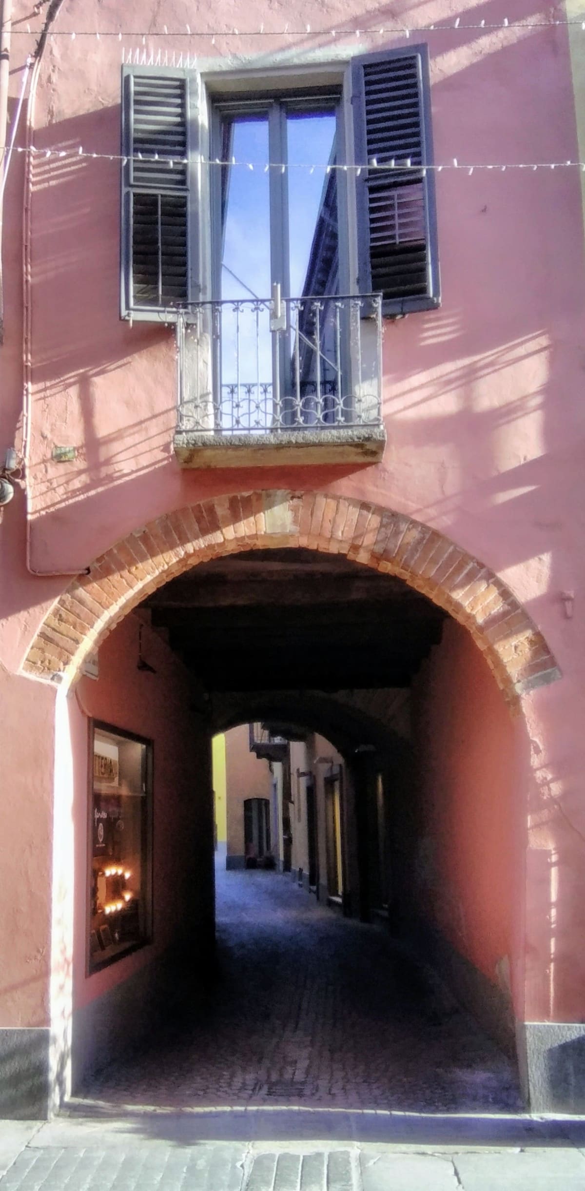 un passaggio ad arco sotto una casa rosa, fra le vie del centro