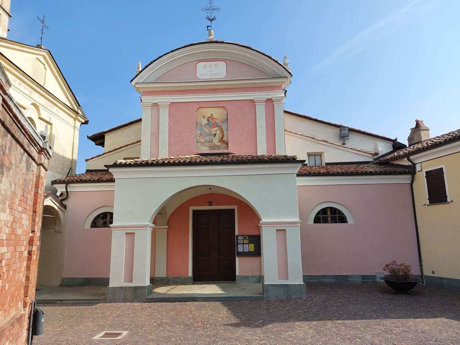 la facciata rosa di San Donato con il portico bianco, su Piazza Falletti