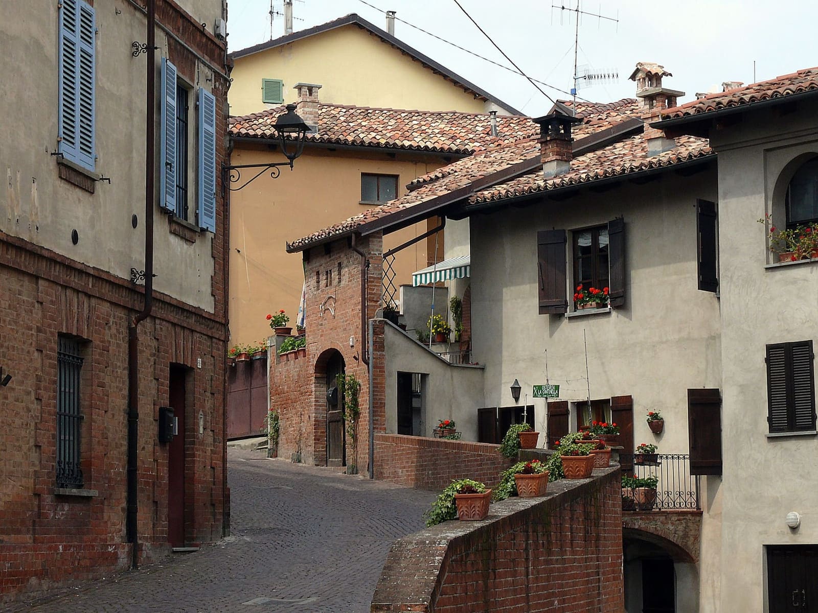 case di mattoni e intonaco e tetti di coppi in una via del centro