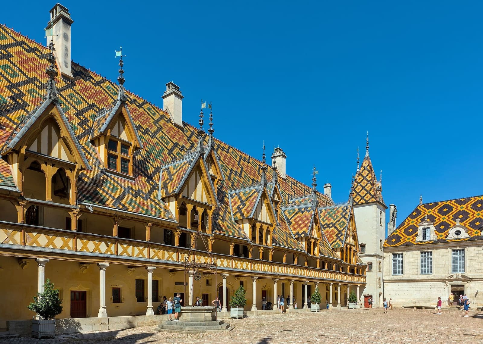 il cortile dell'Hôtel-Dieu, con i tetti di tegole verniciate a losanghe e le gallerie di legno
