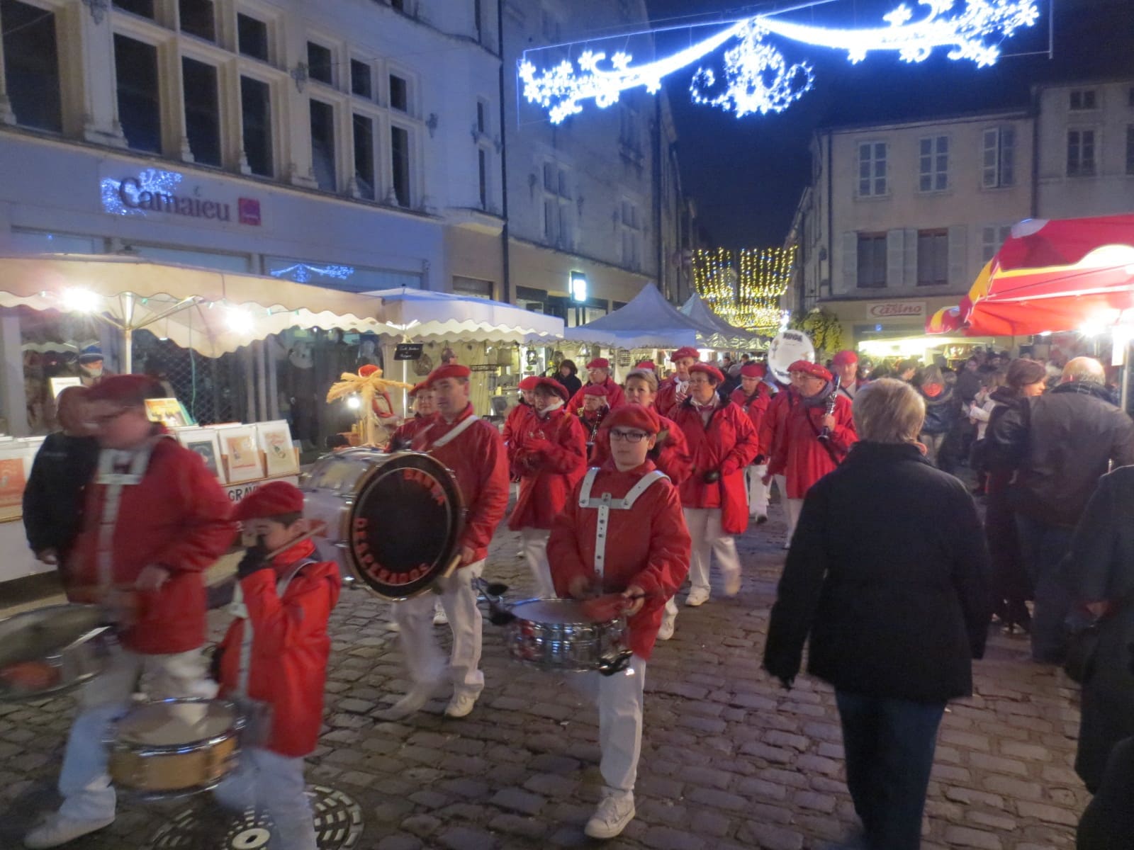 una banda in giacca rossa per le strade, la sera della festa dell'asta