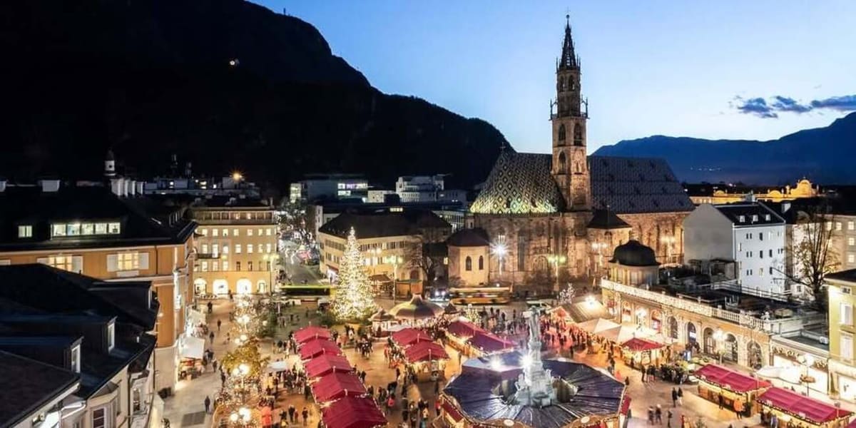 Piazza Walther dall'alto al crepuscolo, le casette rosse del mercatino e il campanile del Duomo