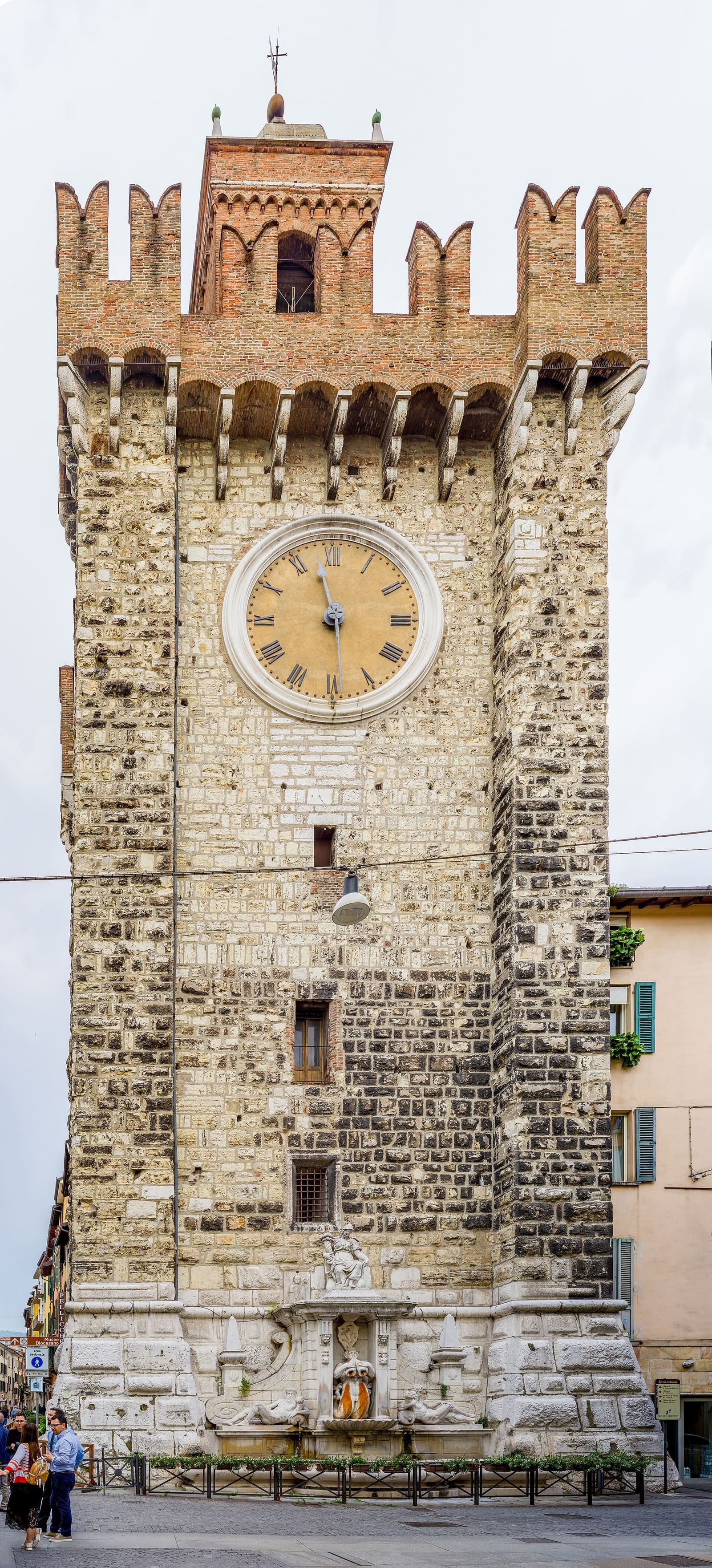 la Torre della Pallata con l'orologio e i merli, e la fontana ai suoi piedi