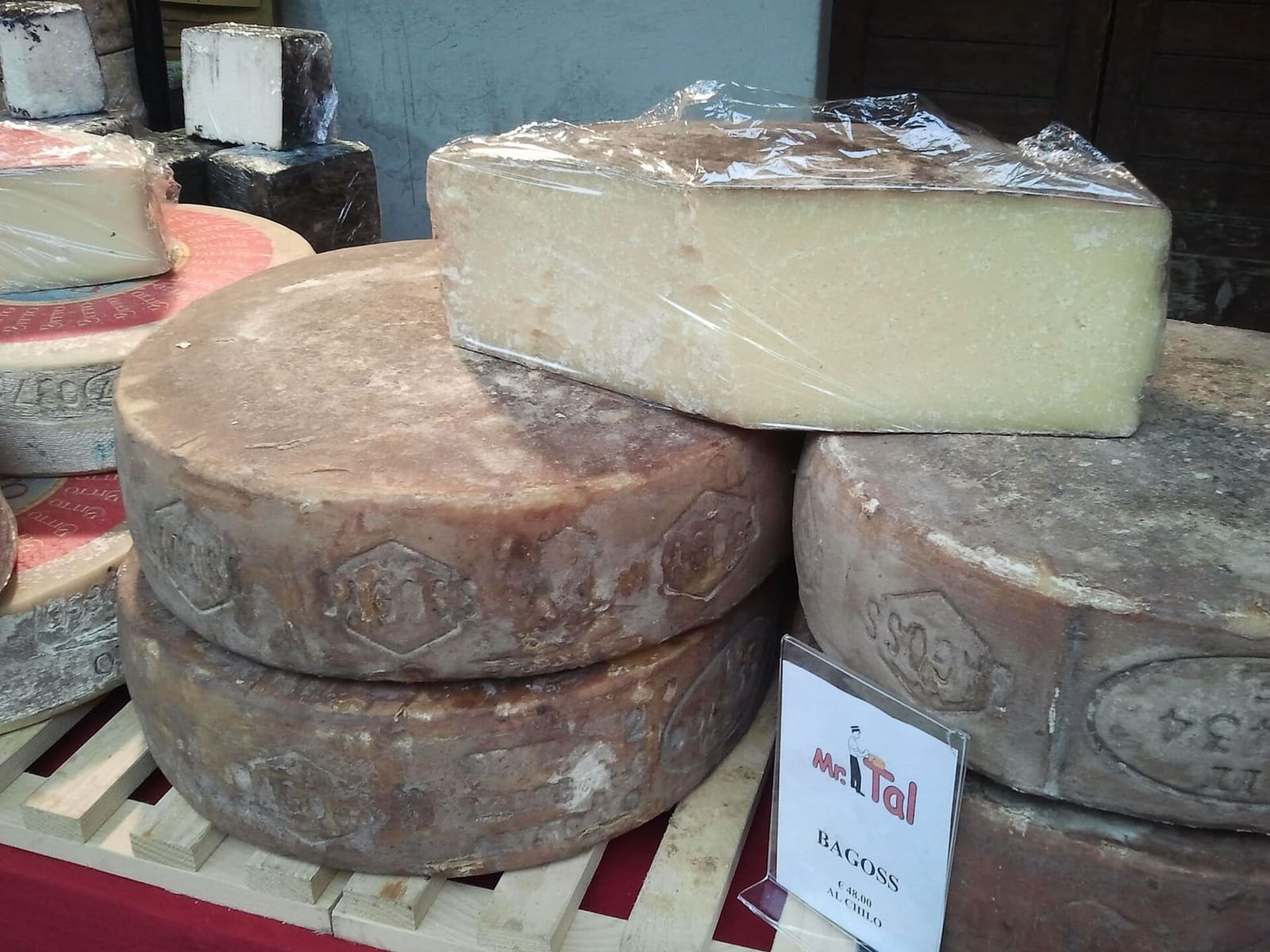 le forme di Bagòss, con la crosta scura, su un banco di formaggi
