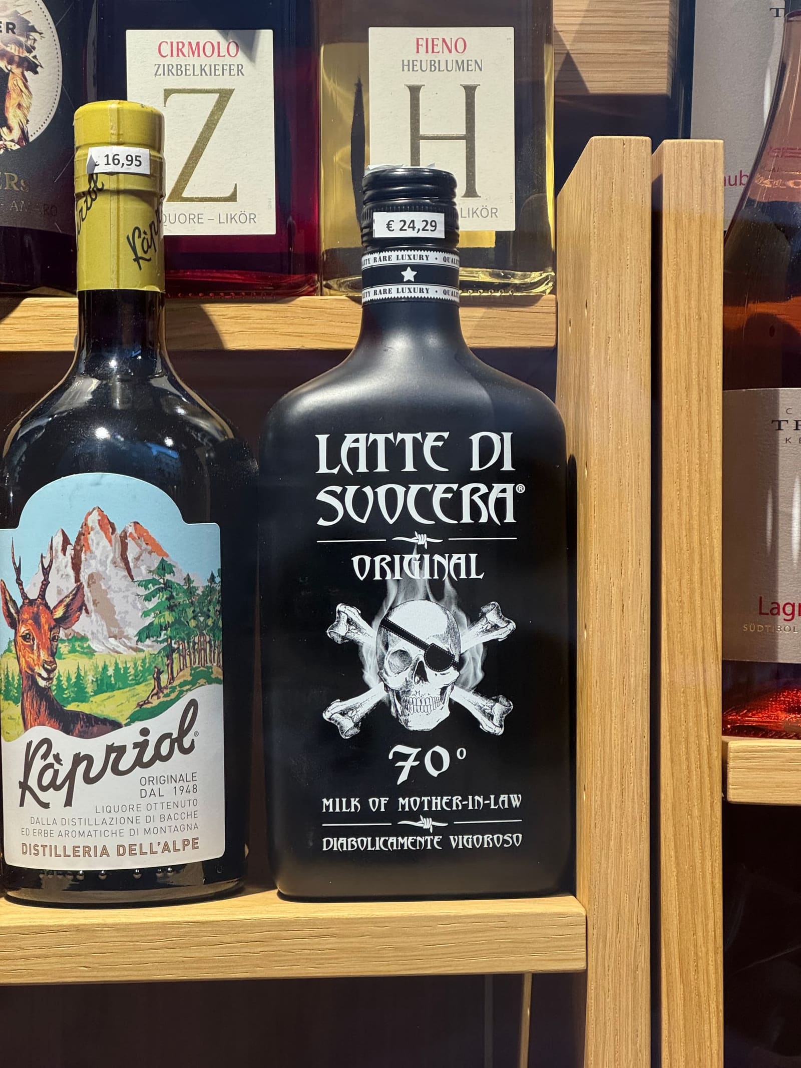 le bottiglie dei liquori di montagna in vetrina, dal Kàpriol al Latte di Suocera