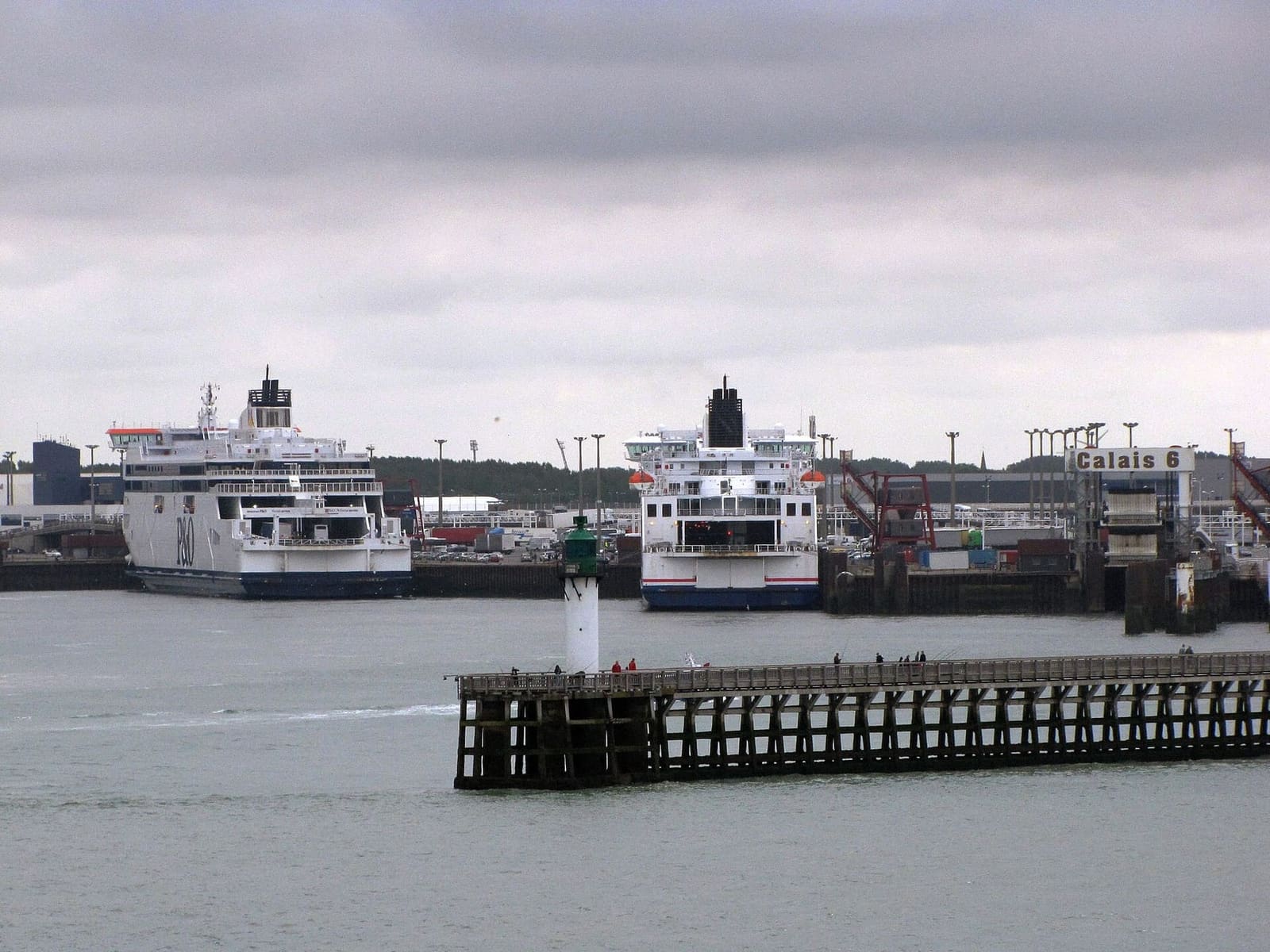 due traghetti ormeggiati al terminal, dietro il faro della jetée