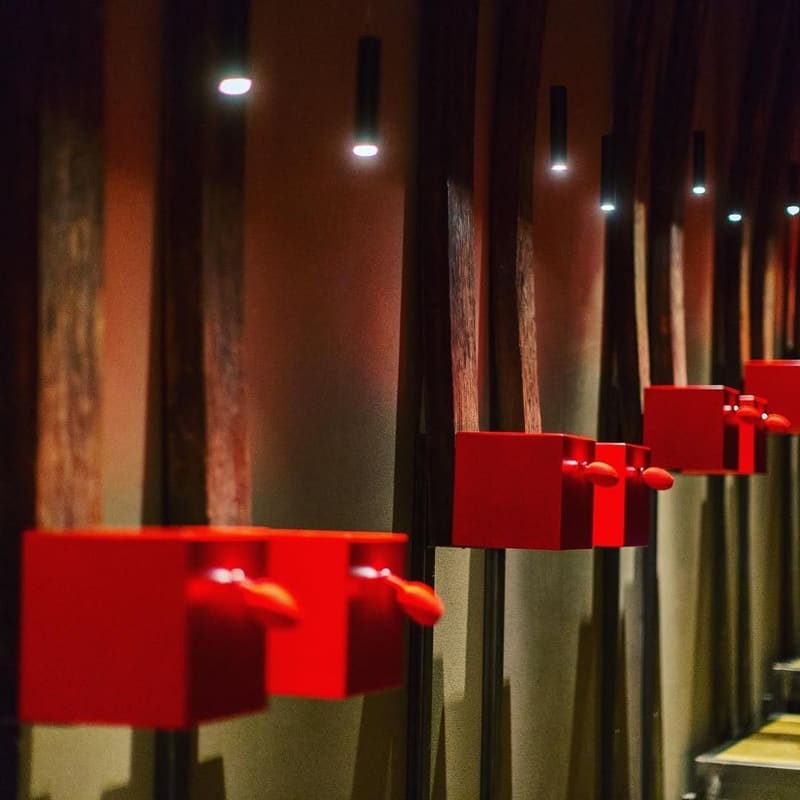 i diffusori rossi della Galleria Olfattiva, nella penombra della Sala Bottaia