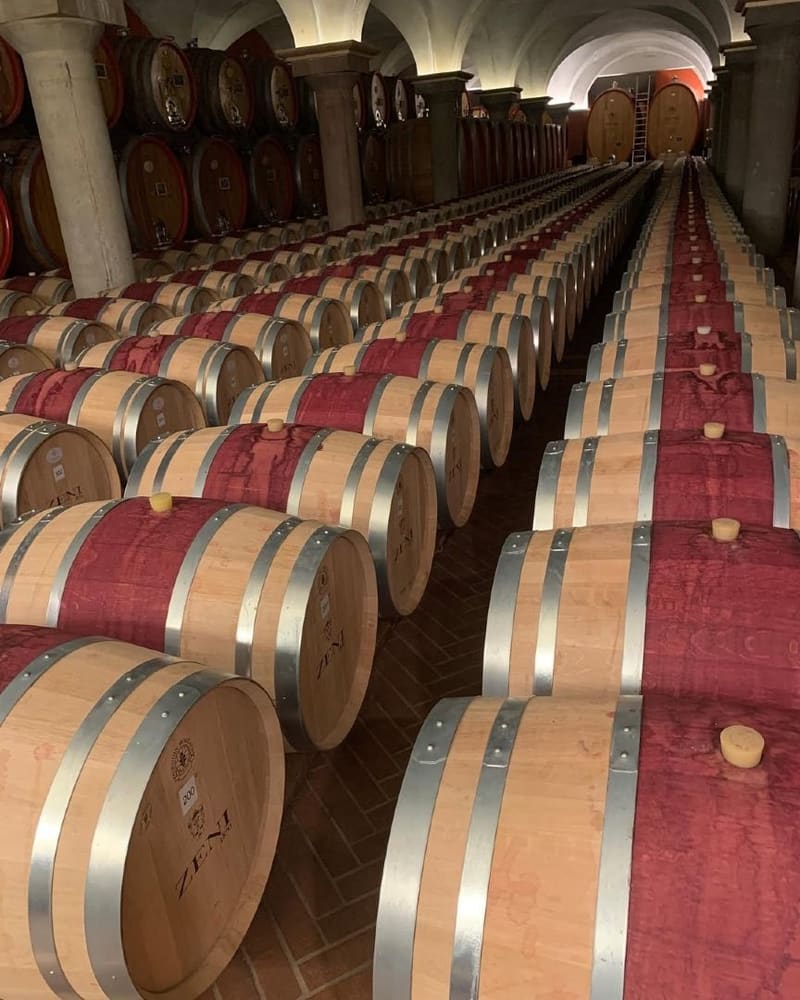 le file di barrique nella cantina di affinamento, sotto le botti grandi