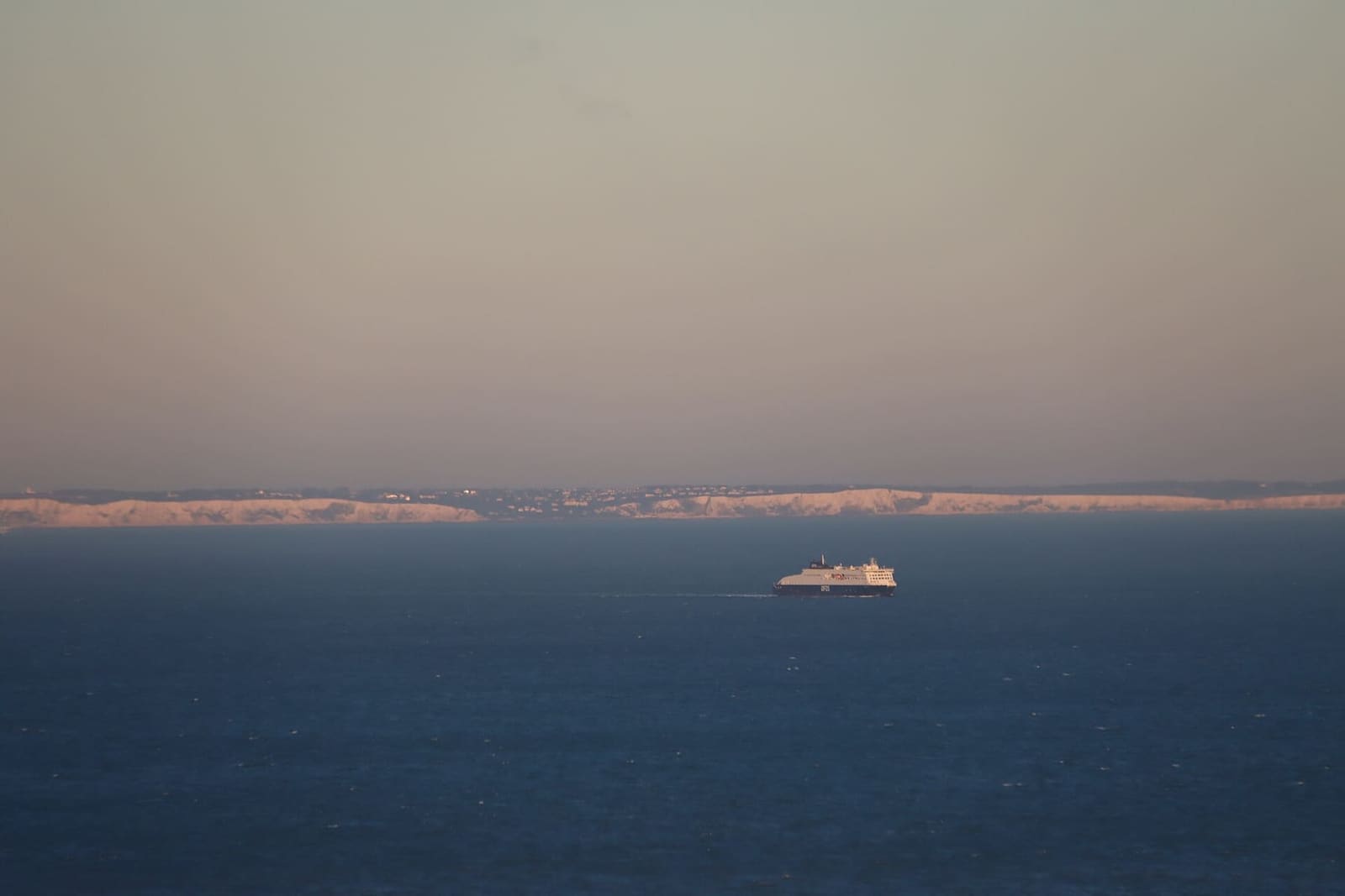 a ferry in the strait and the white cliffs of England on the horizon, from Blanc-Nez