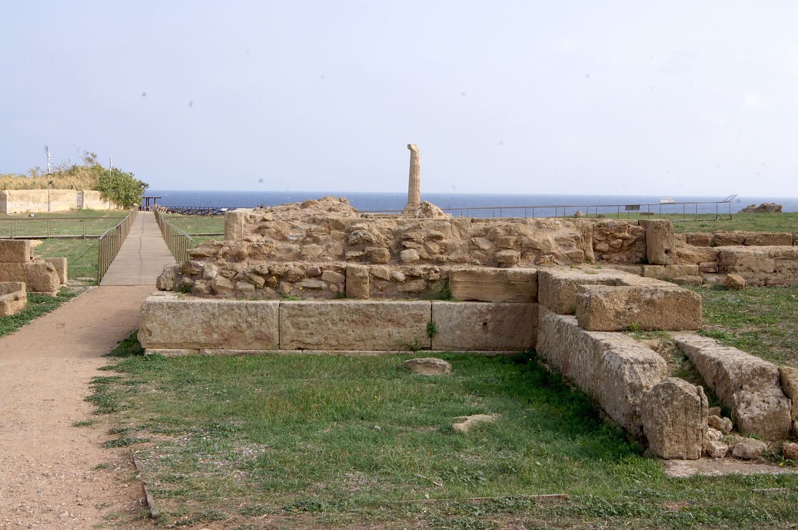 les vestiges du sanctuaire le long du sentier d'entrée, avec la colonne au fond