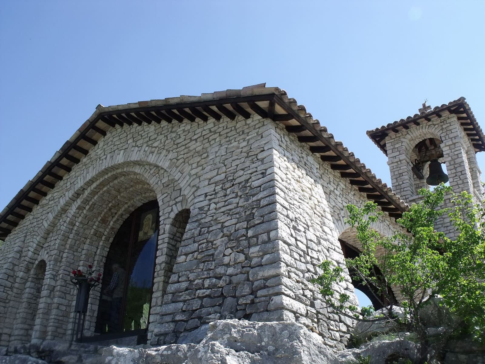 la facciata di pietra della cappella dello Scoglio, con il campanile