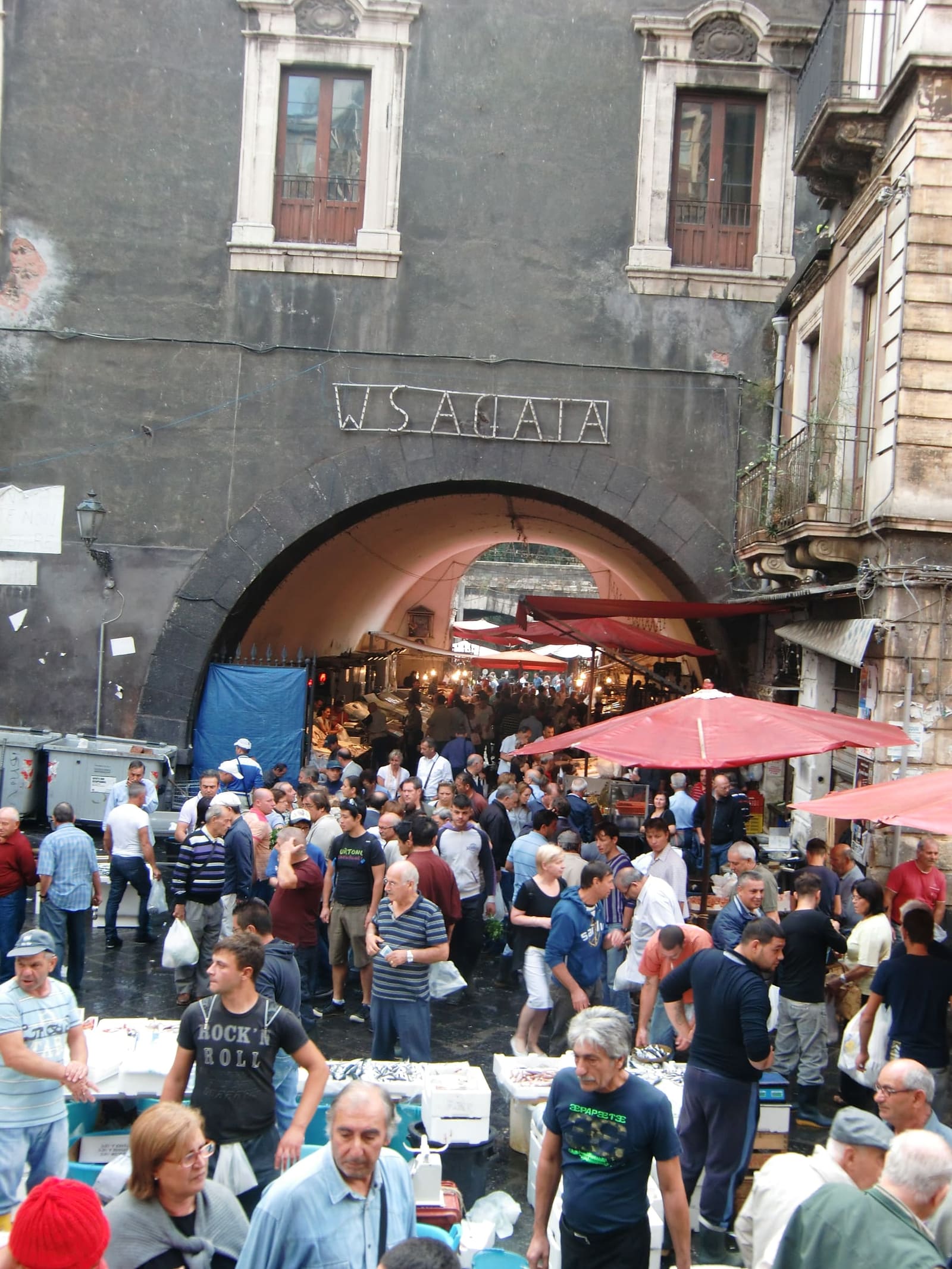 la folla della Pescheria sotto l'arco con la scritta W S. Agata