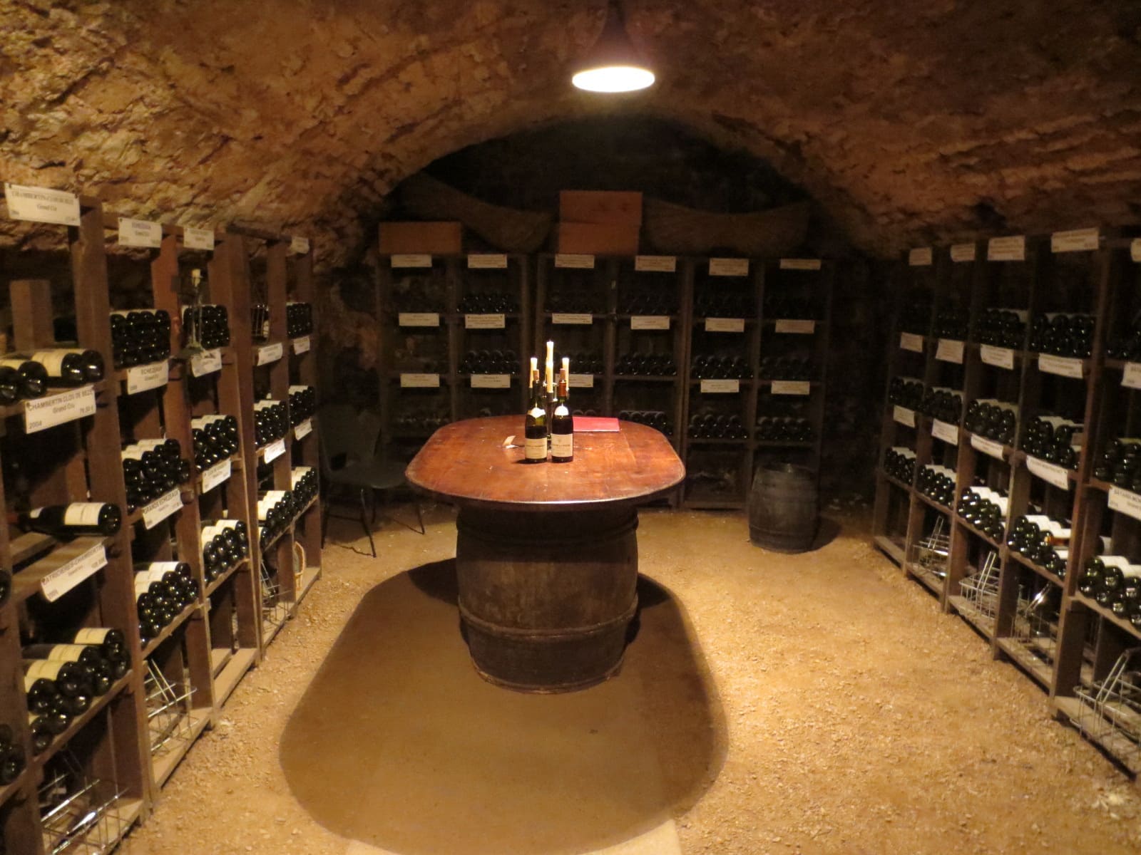 la cantina delle bottiglie vecchie, con un tavolo fatto di una botte in mezzo