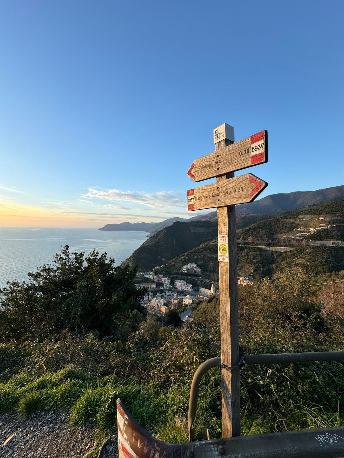 il palo del sentiero 593V con le frecce per Riomaggiore e per la Madonna di Montenero, al tramonto