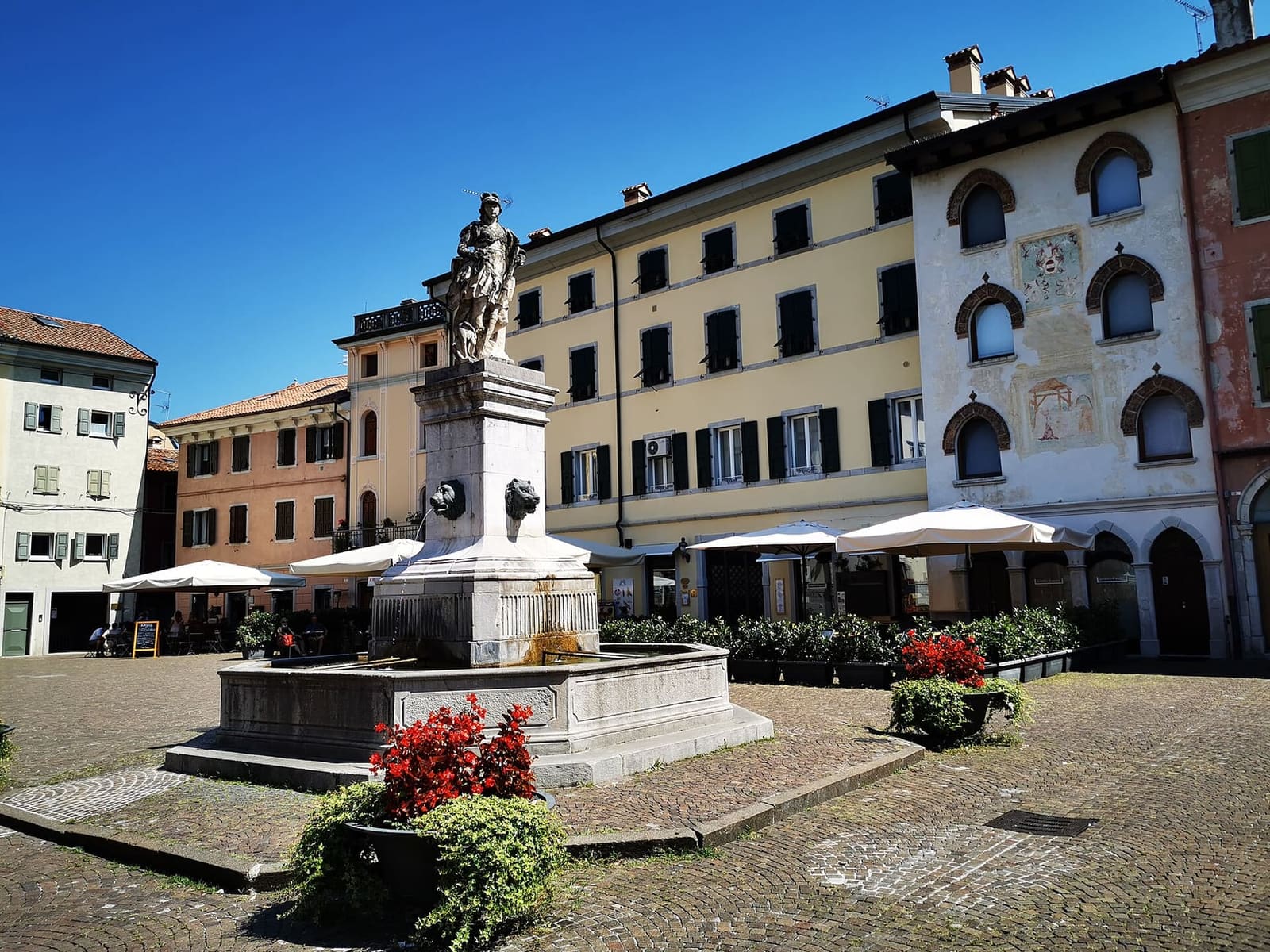 la piazza Paolo Diacono avec la fontaine et les maisons peintes