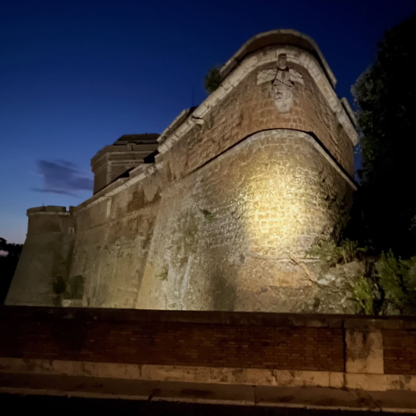 il bastione del forte da vicino, con la testa scolpita sullo spigolo che la luce prende di taglio