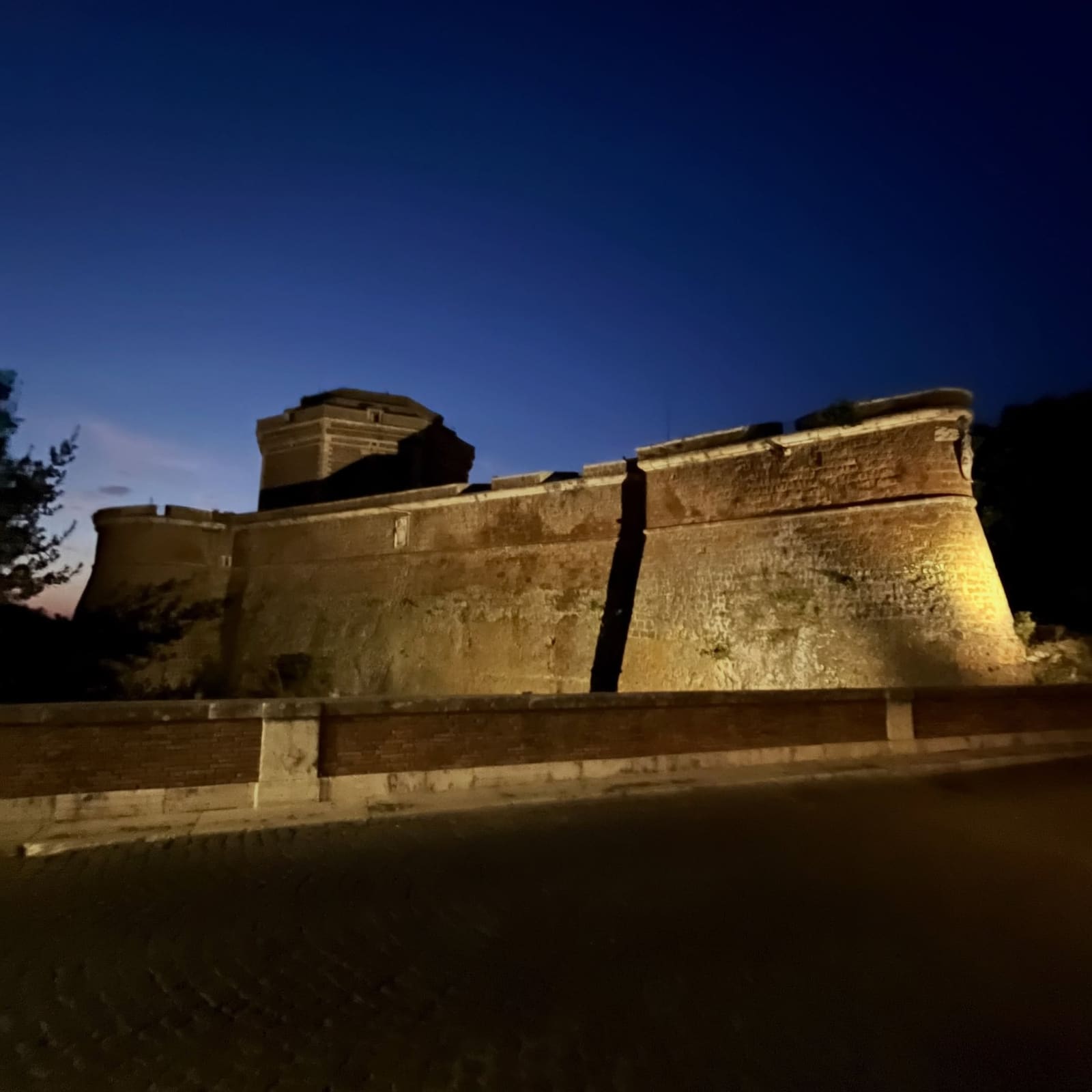 il Forte Sangallo illuminato all'ora blu, visto dalla strada che gli passa sotto