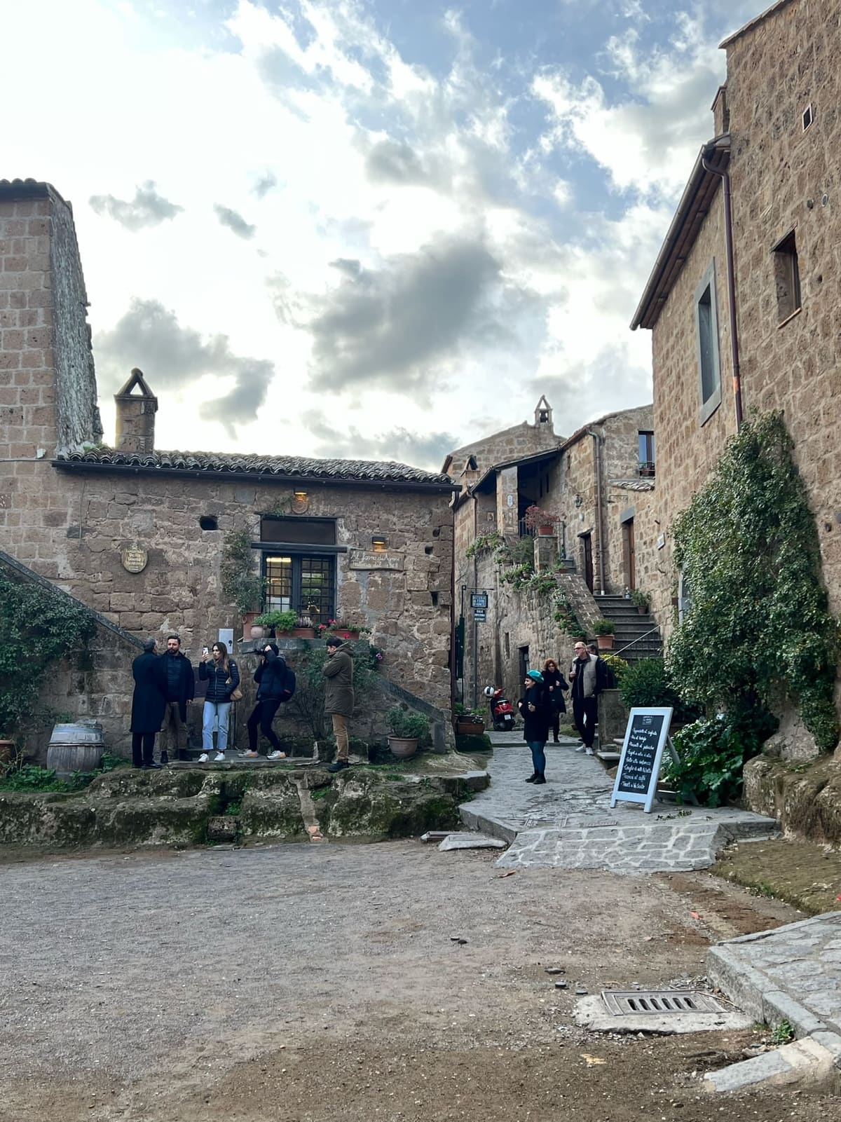 lo slargo davanti alla trattoria, con la lavagna del menu e le case di tufo