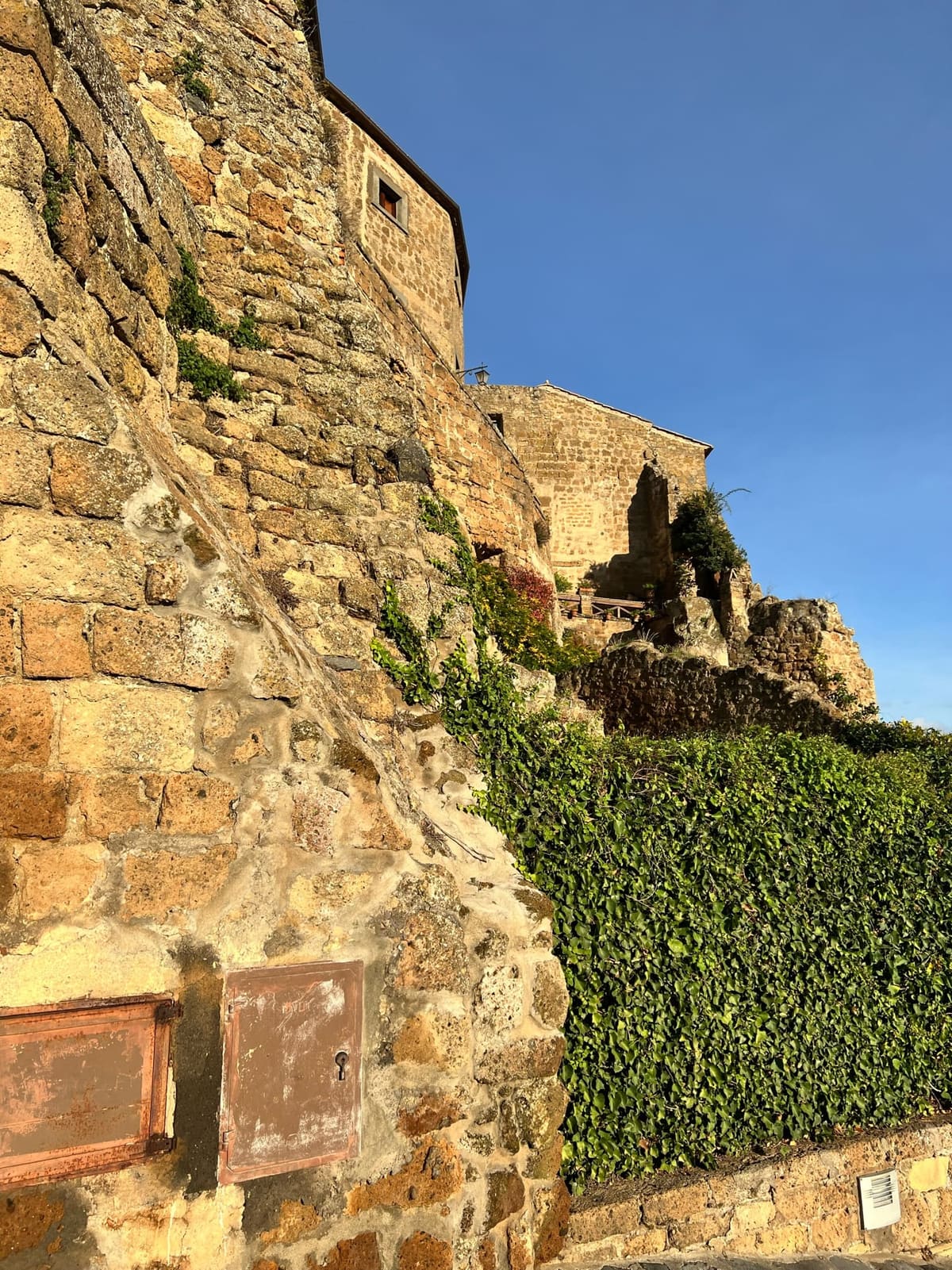 il muro di tufo coperto d'edera sotto Porta di Santa Maria, sulla via del ritorno