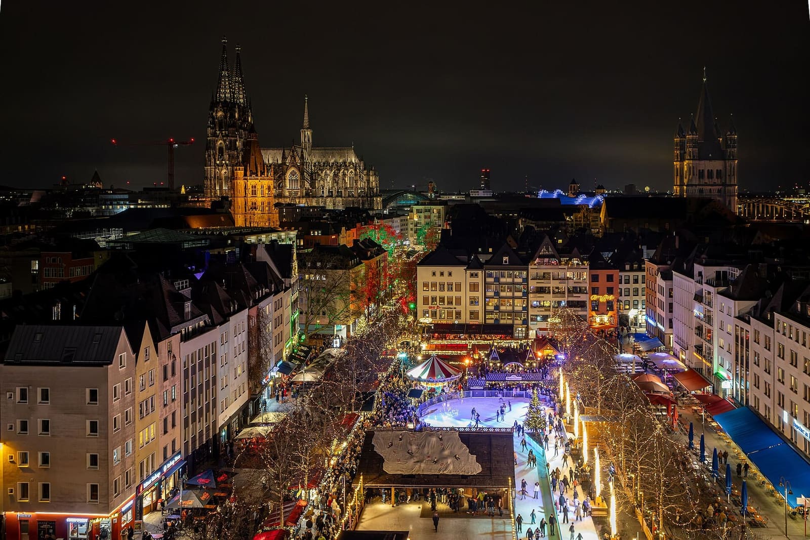 la pista di pattinaggio sull'Heumarkt vista dall'alto di notte, con il Duomo e Groß St. Martin sullo sfondo