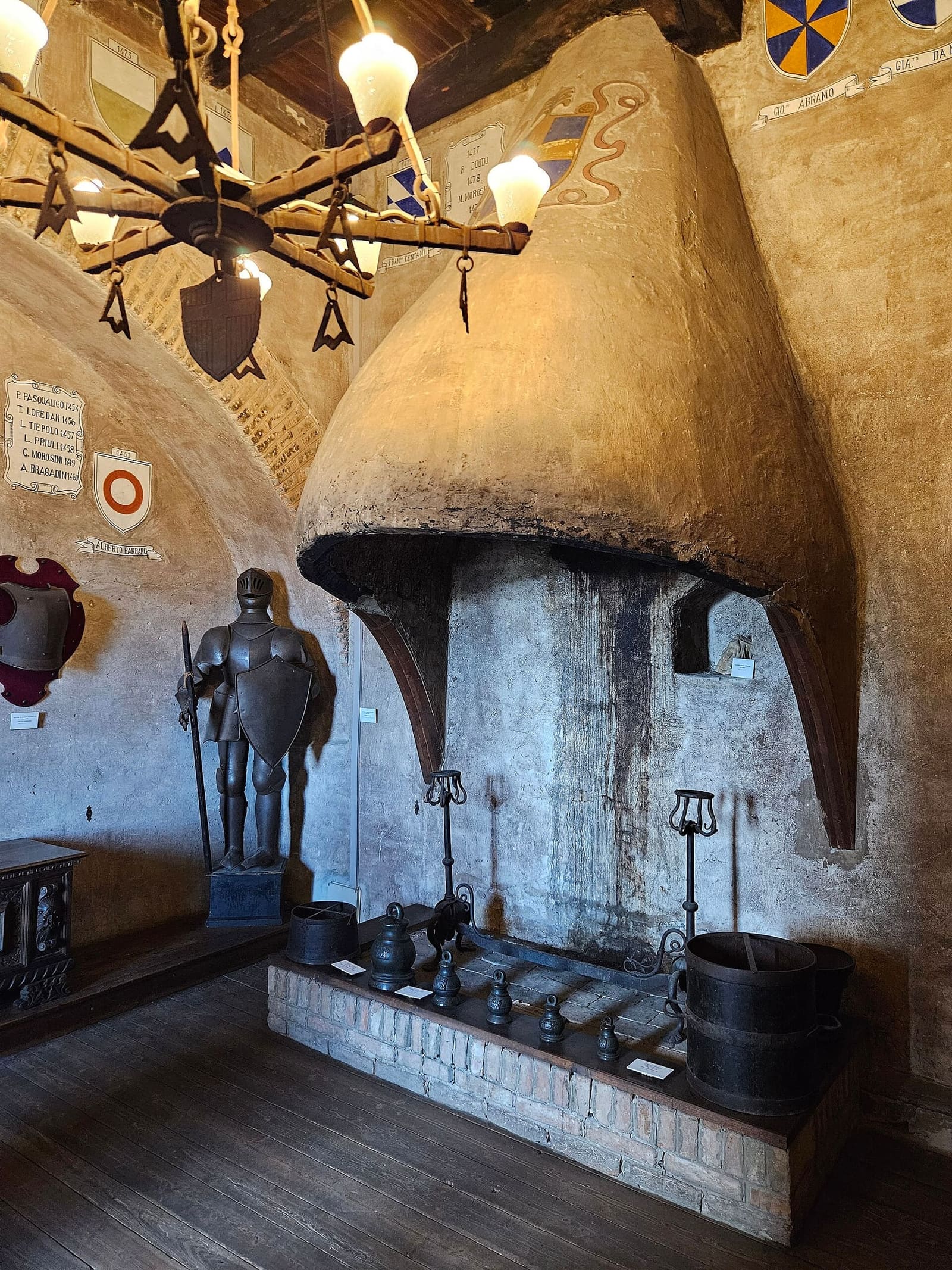 il grande camino e un'armatura in una sala del Museo civico del castello