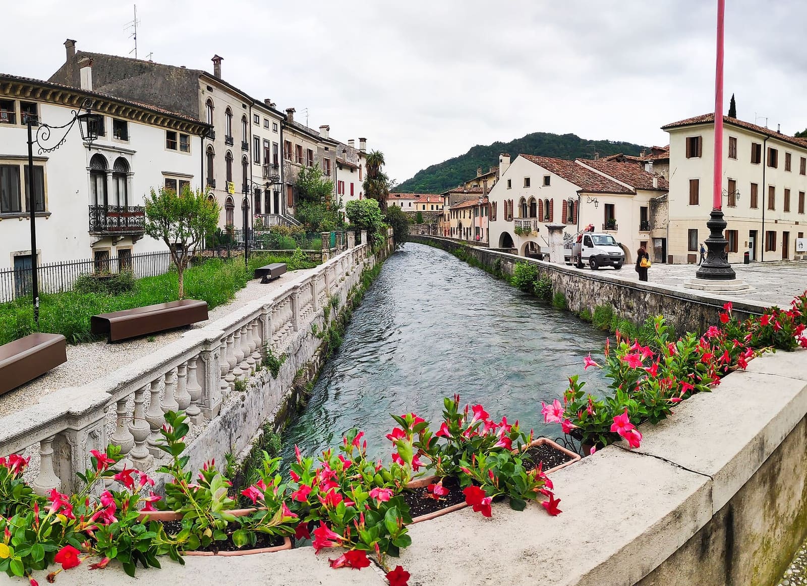 il Meschio fra le case di Serravalle, con i fiori sulla balaustra, in una giornata di maggio