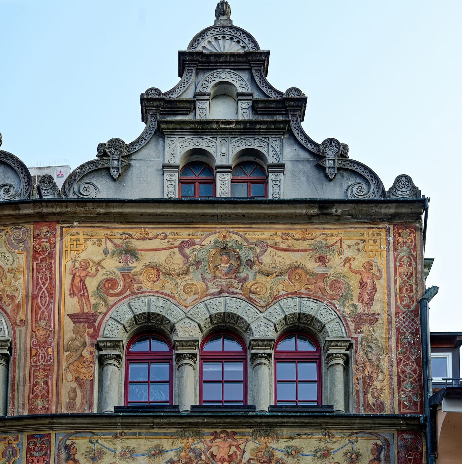 la facciata dipinta del Rathaus, con le finestre a tutto sesto e il frontone