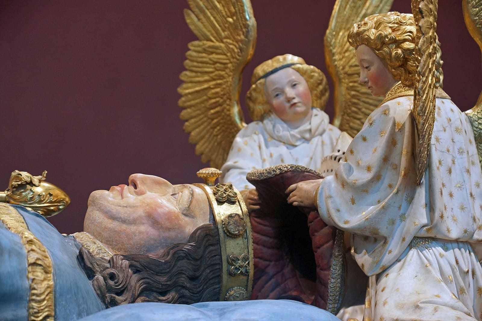 gli angeli d'oro che reggono l'elmo sopra la statua del duca