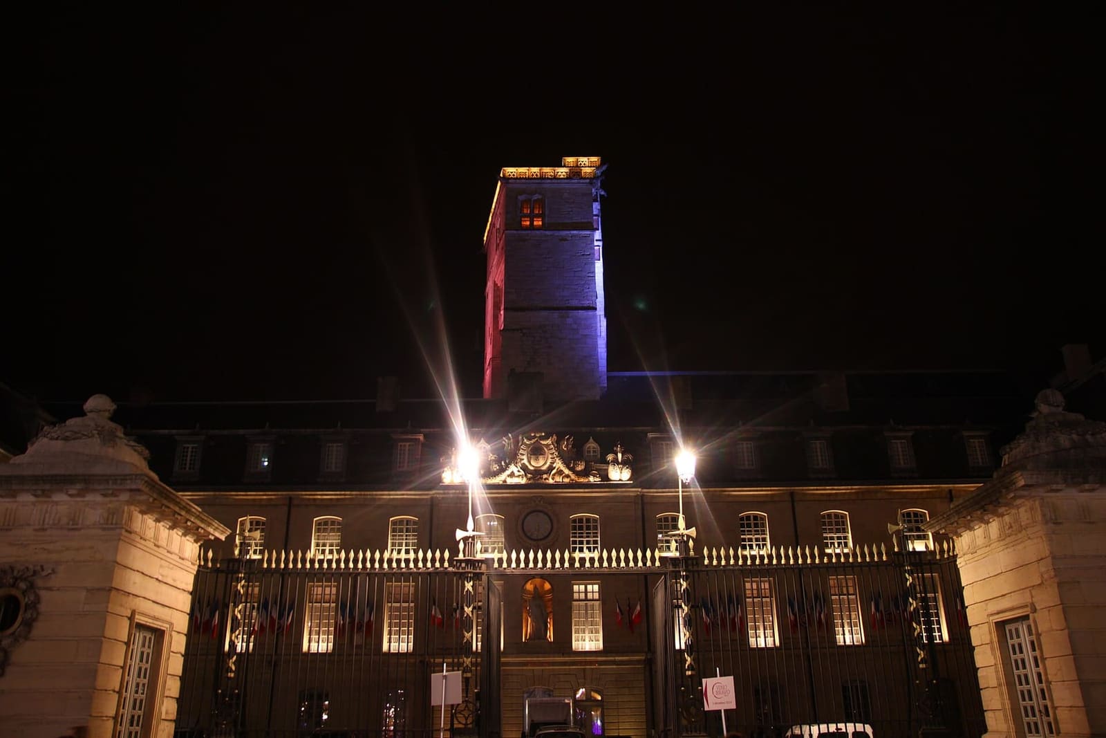il palazzo dei duchi illuminato una sera di dicembre, con la torre accesa di rosso