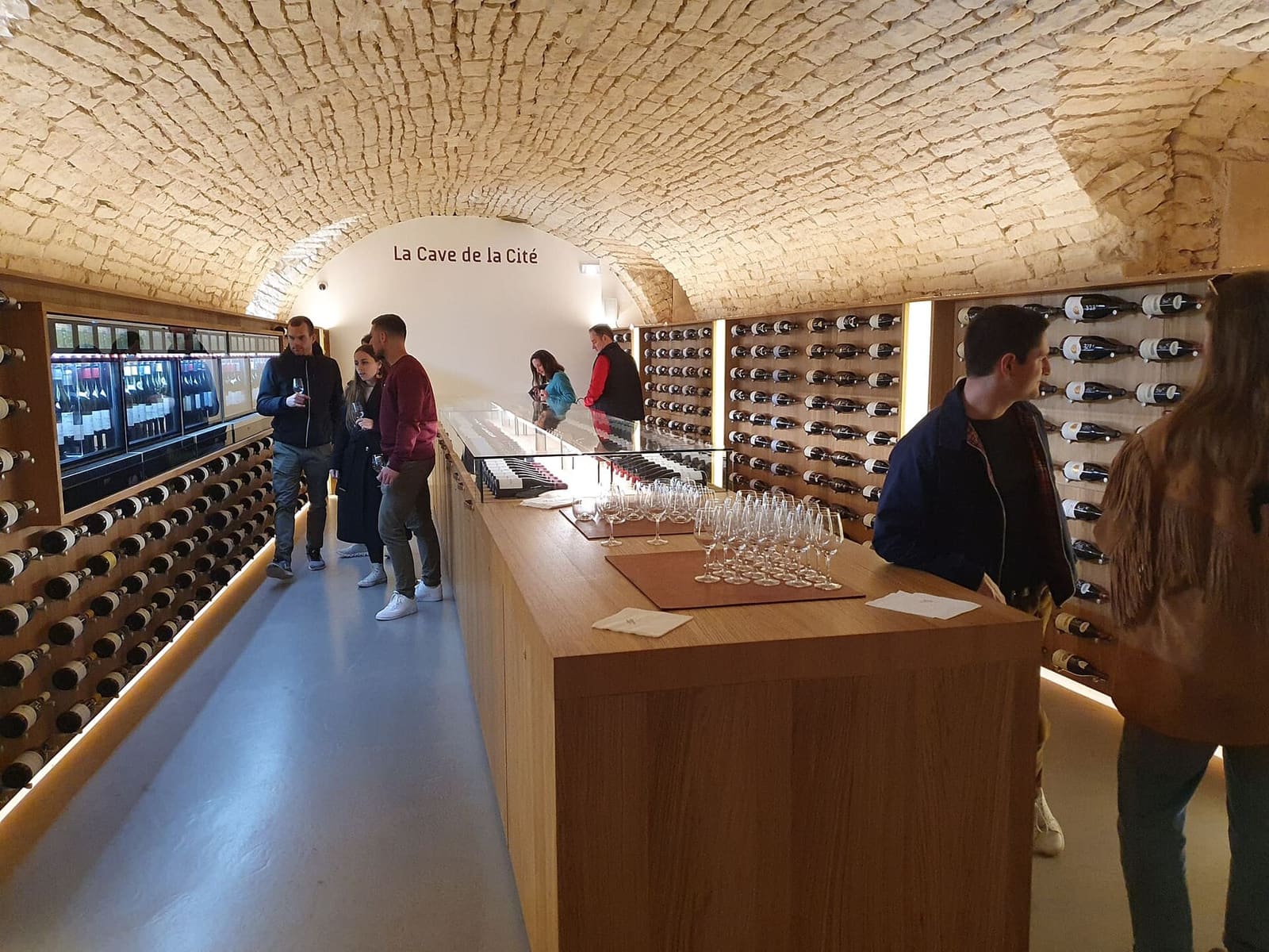 la cantina a volta della Cave de la Cité, con il banco e le bottiglie