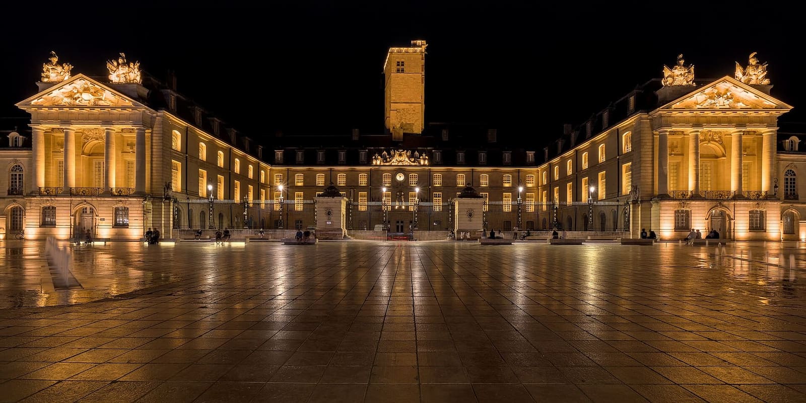 la place de la Libération di notte, con il palazzo dei duchi illuminato e la torre di Filippo il Buono in mezzo