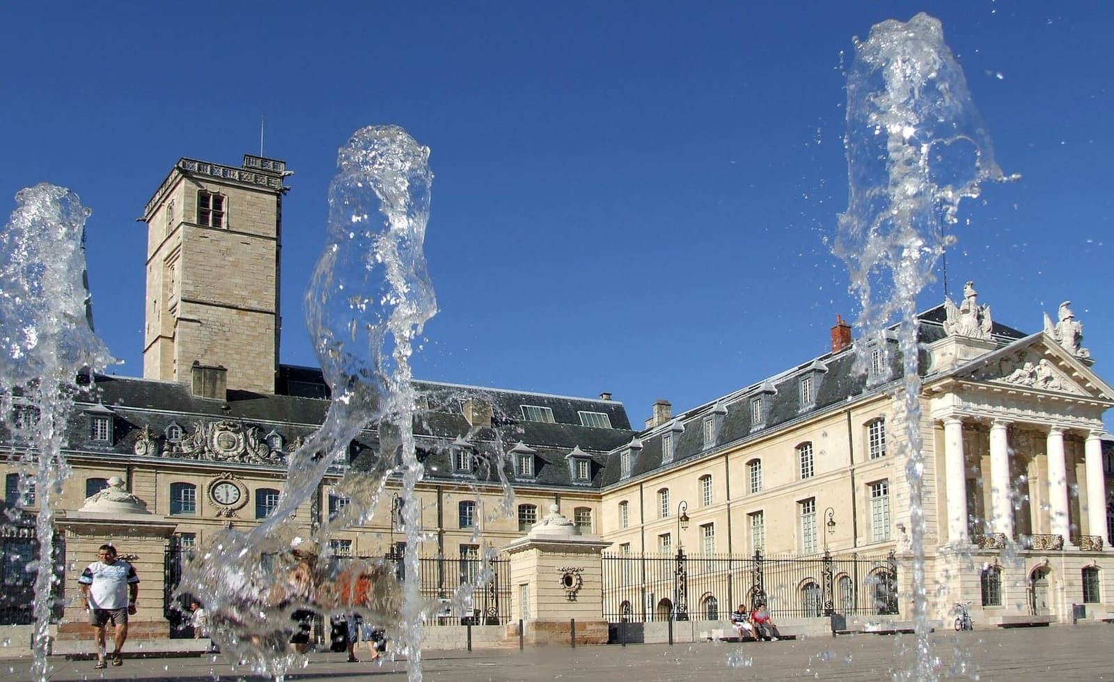 le fontane nel selciato della place de la Libération, con il palazzo e la torre