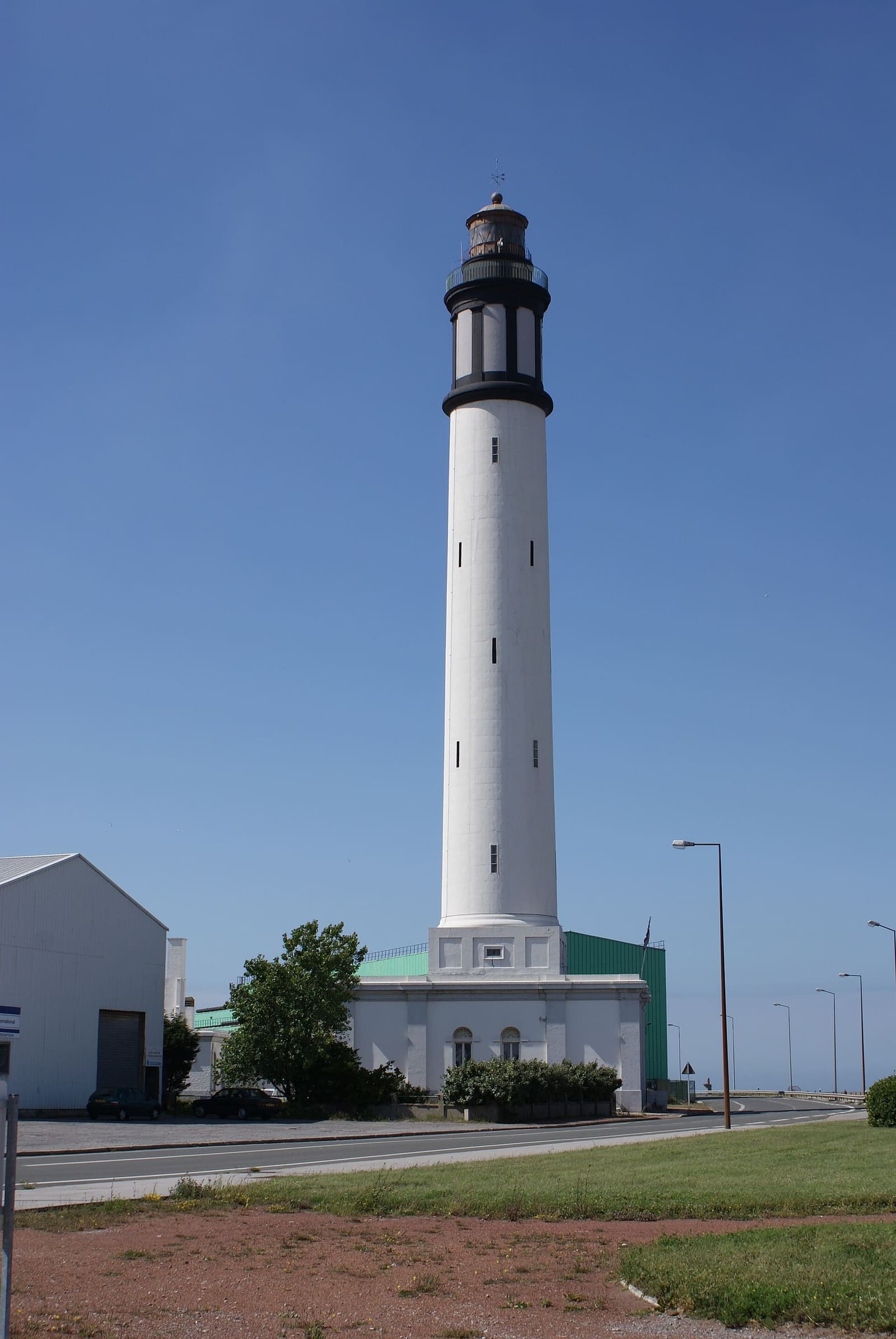 the white Risban lighthouse, 60 metres tall, under a blue sky