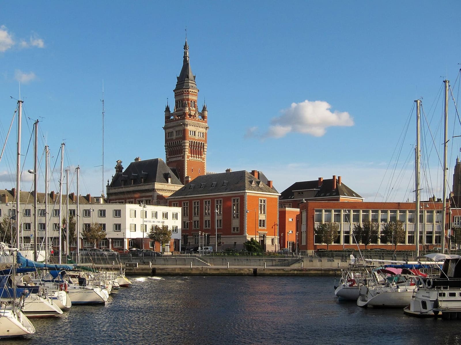 the Hôtel de ville above the marina, with sailing boats moored in the basin