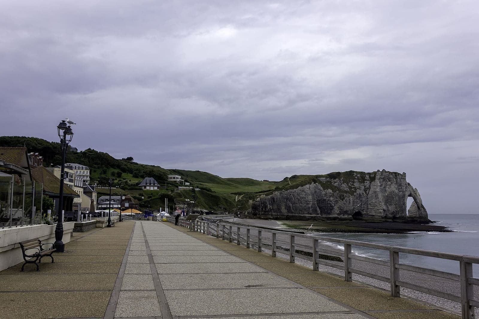 die Strandpromenade über dem Strand, fast leer, hinten die Falaise d'Aval