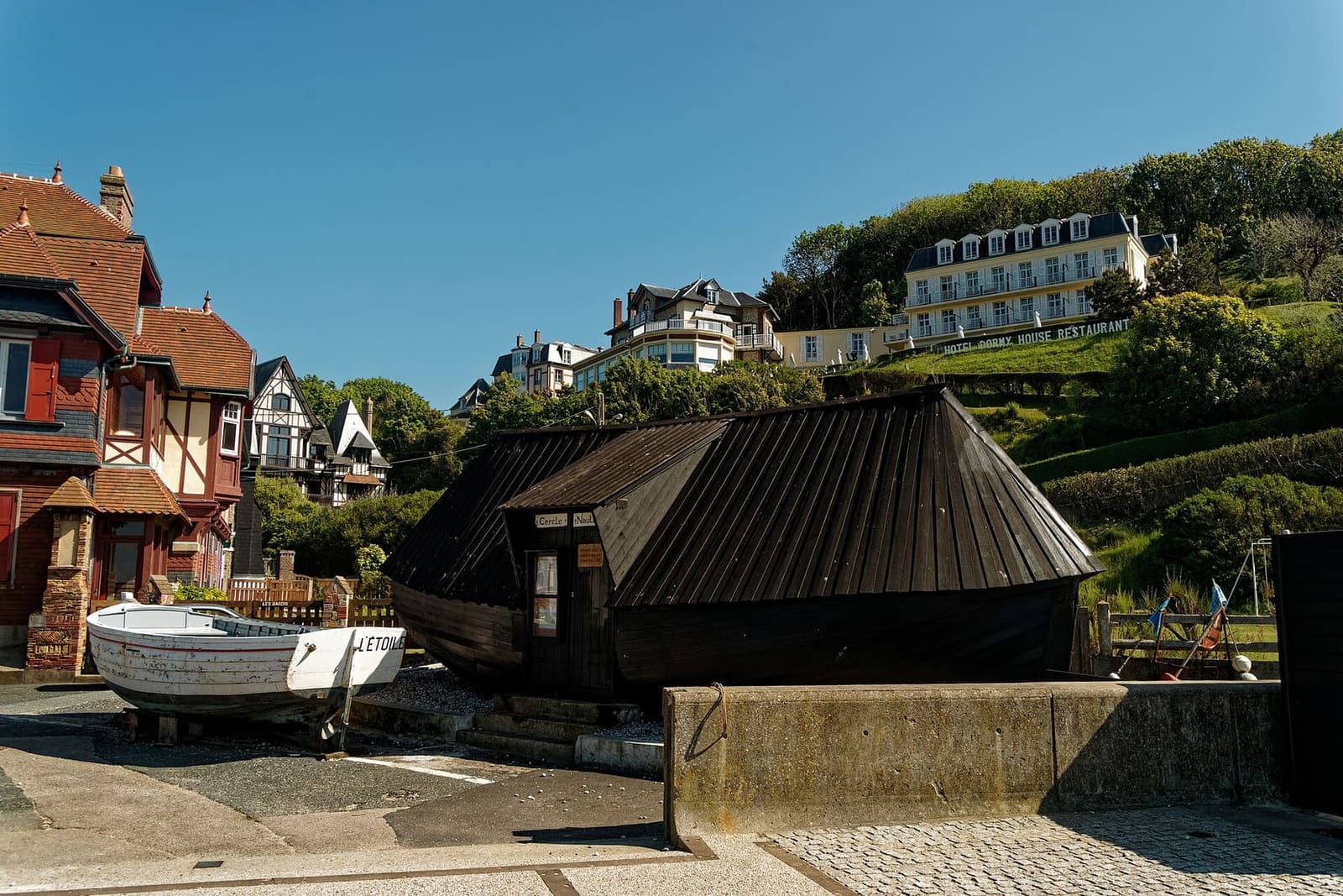 dunkle Holzhütten und ein Boot auf der Terrasse Claude Monet