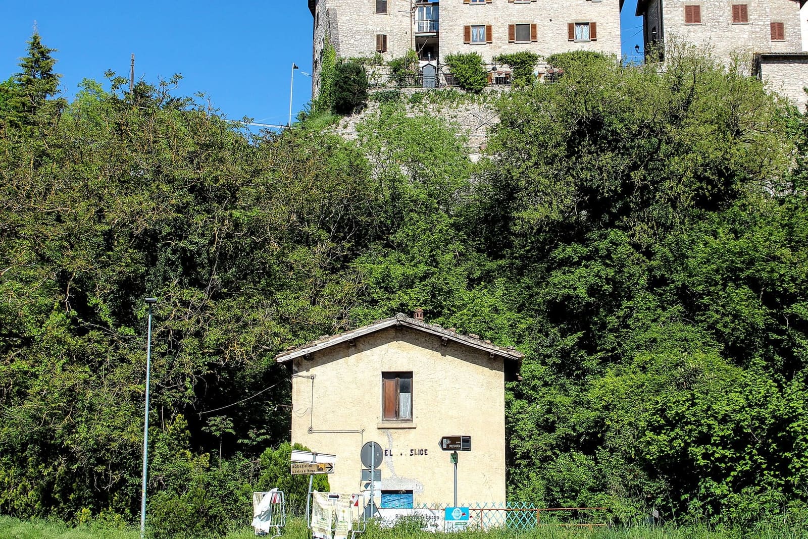 il casello della stazione di Castel San Felice, con le case del borgo in alto fra gli alberi