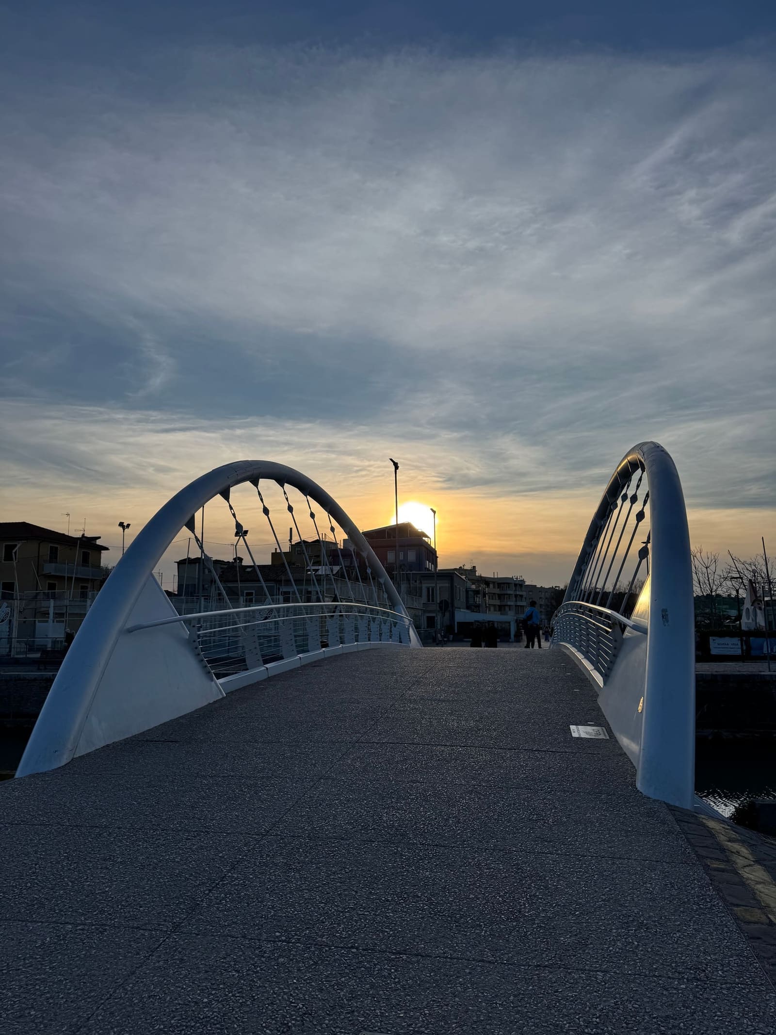il ponte ad arco sul porto, con il sole basso in fondo